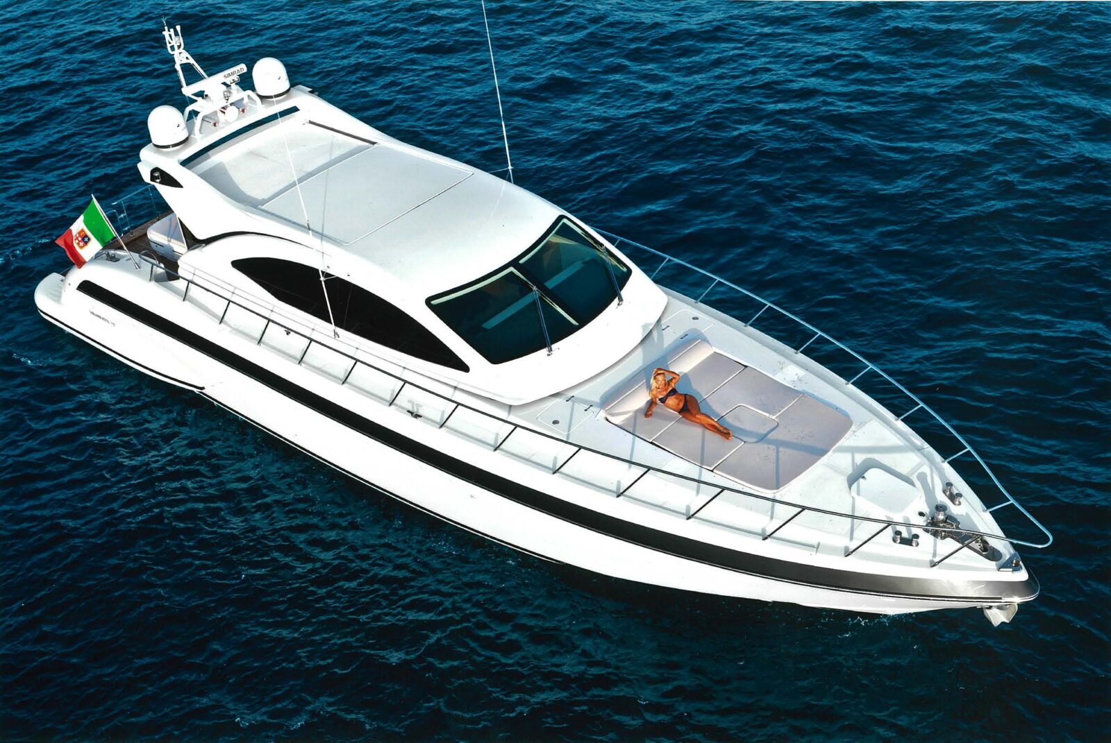 Mangusta yacht cruising with sunbather on deck.