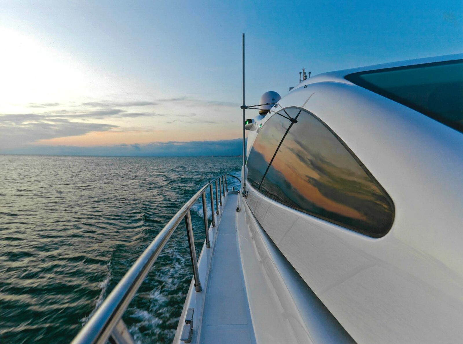 Luxurious Mangusta yacht cruising at sunset.