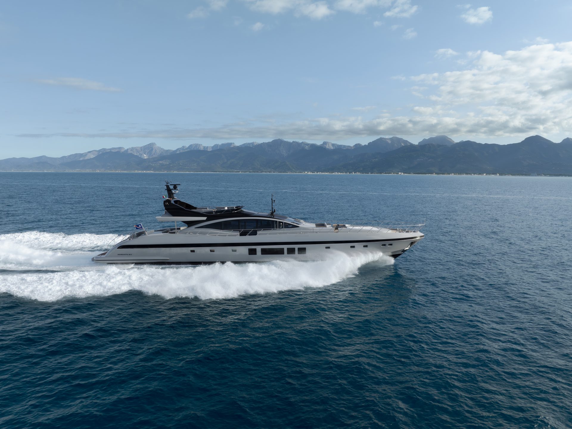 Mangusta yacht cruising on open sea near mountains