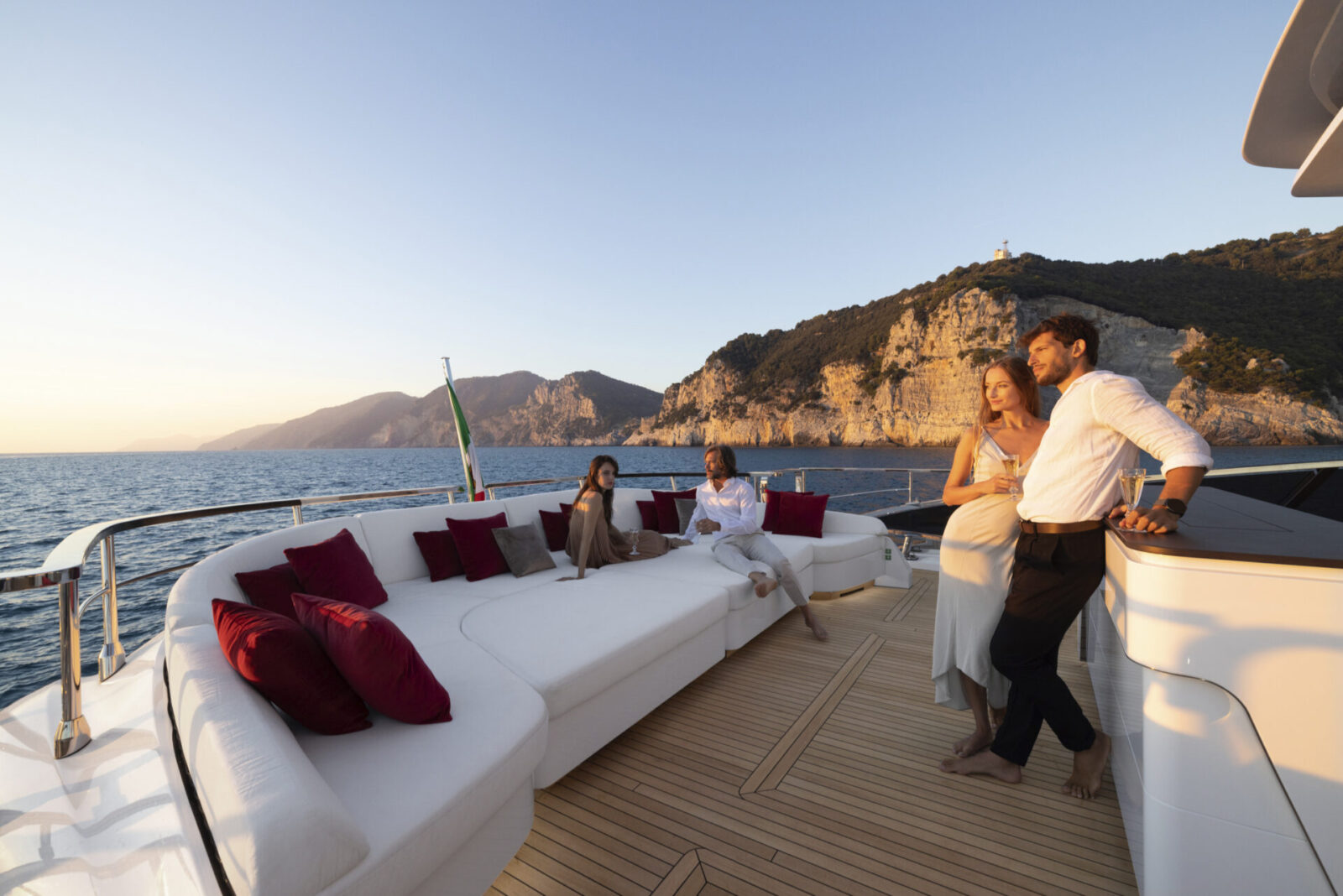 Luxury yacht deck with people enjoying sunset.