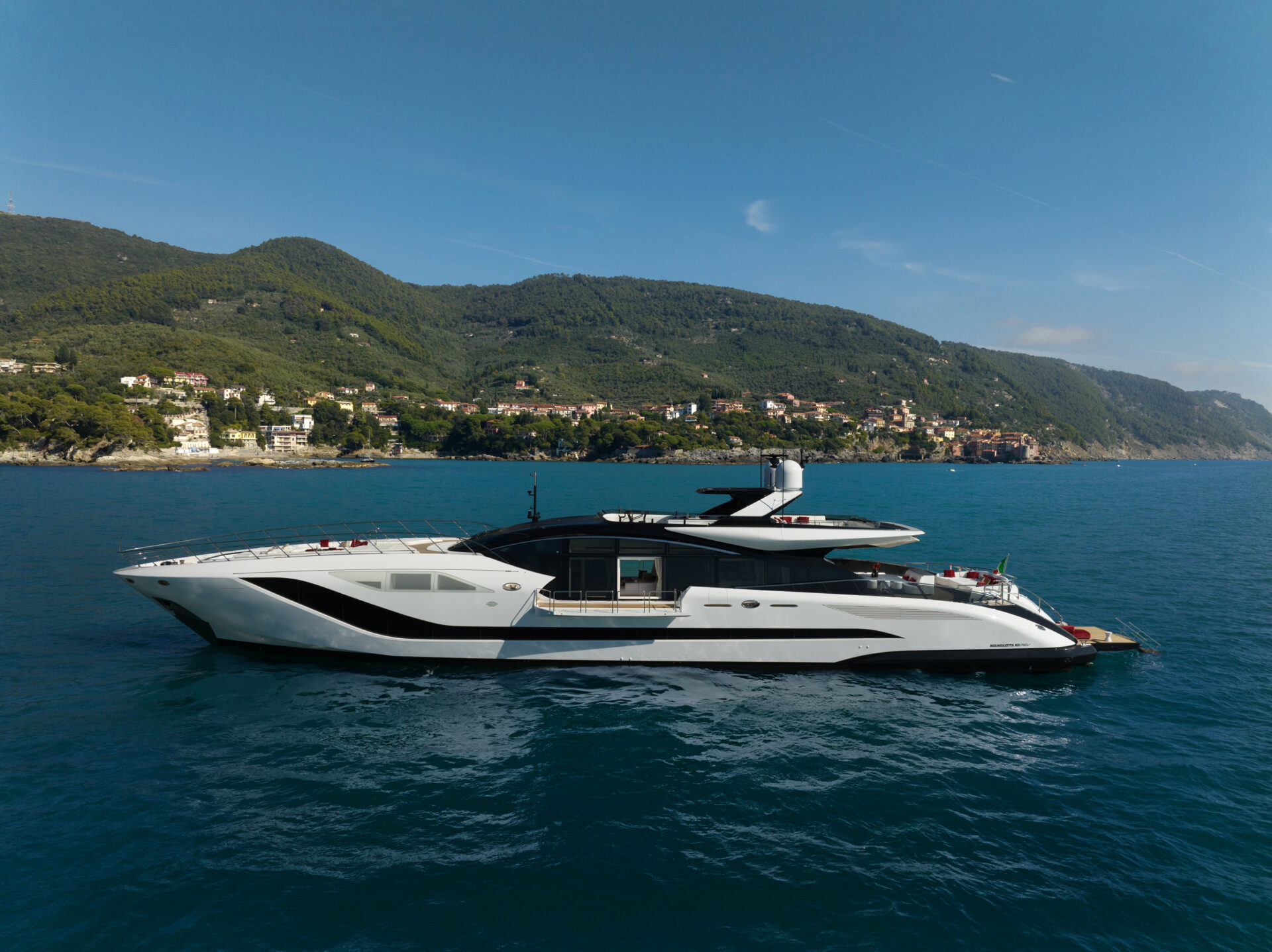 Mangusta Yacht cruising near coastal hills