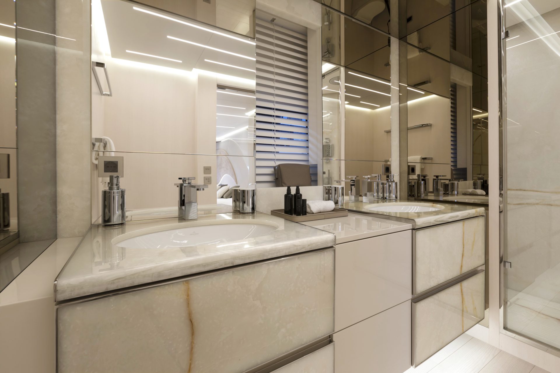 Luxurious yacht bathroom with marble and mirrors.