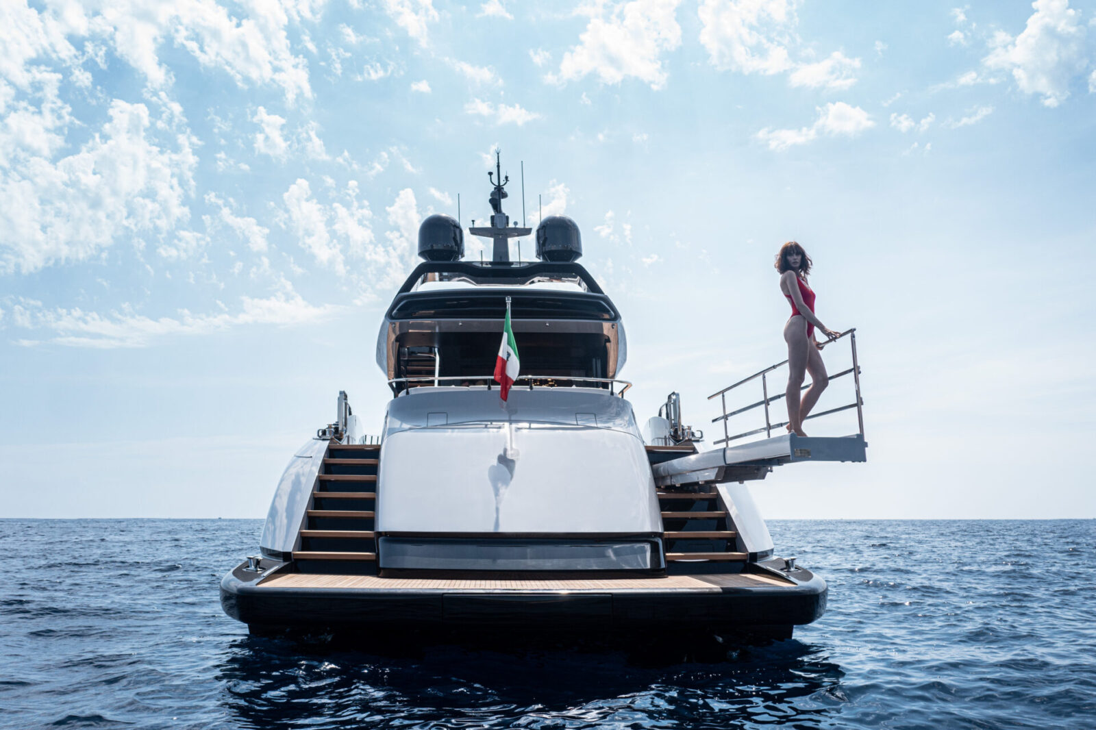 Mangusta Yacht in mare con passerella e cielo azzurro.