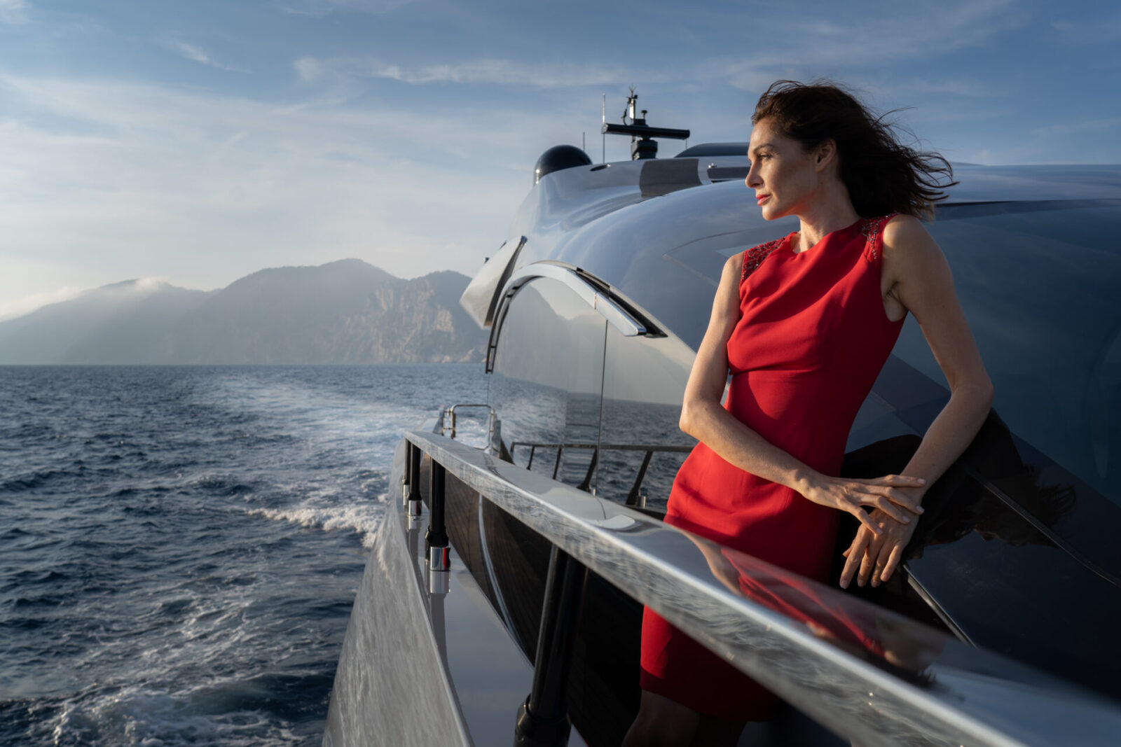 Donna su Mangusta Yacht, panorama marino al tramonto.