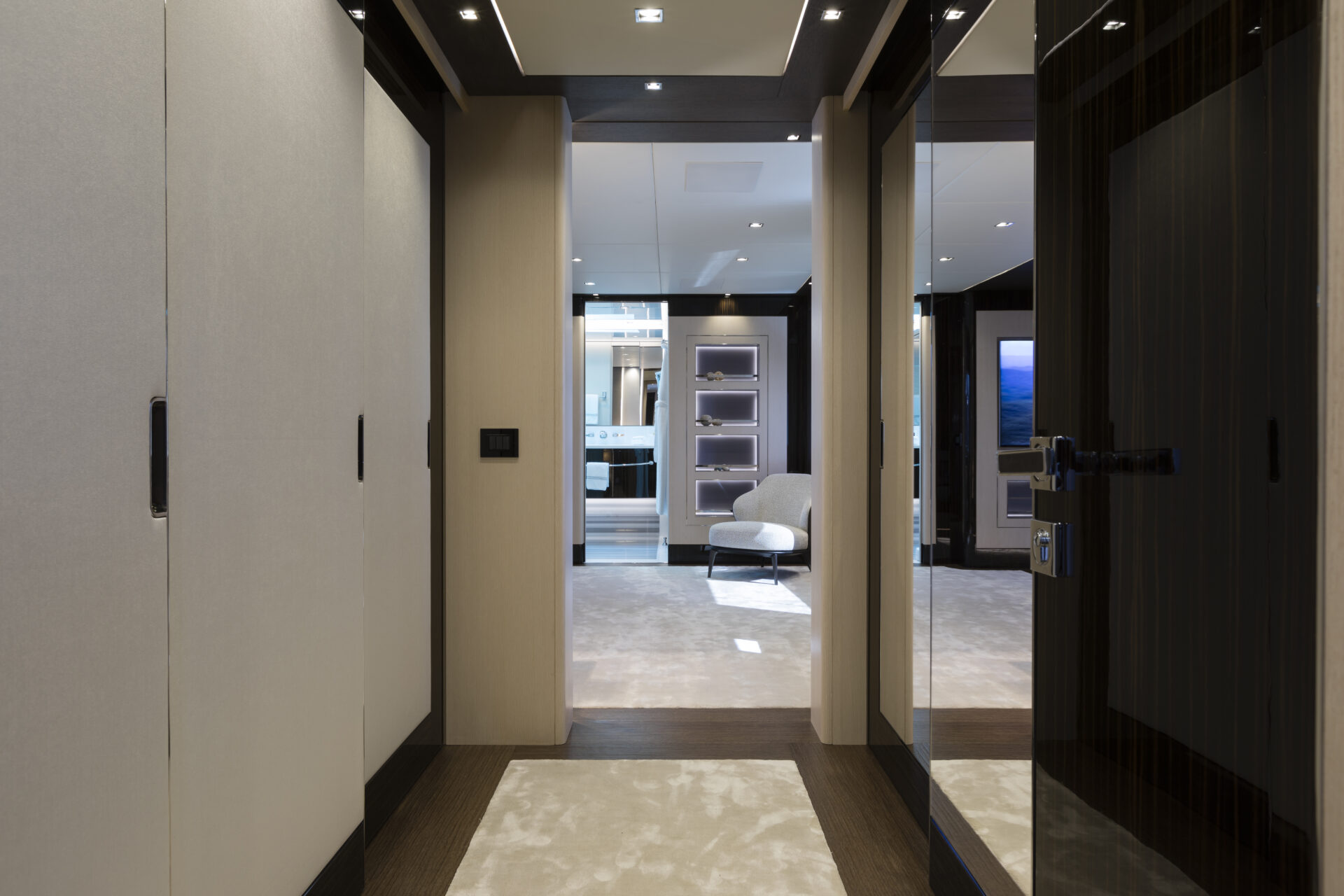 Corridoio elegante con poltrona e illuminazione soffusa.