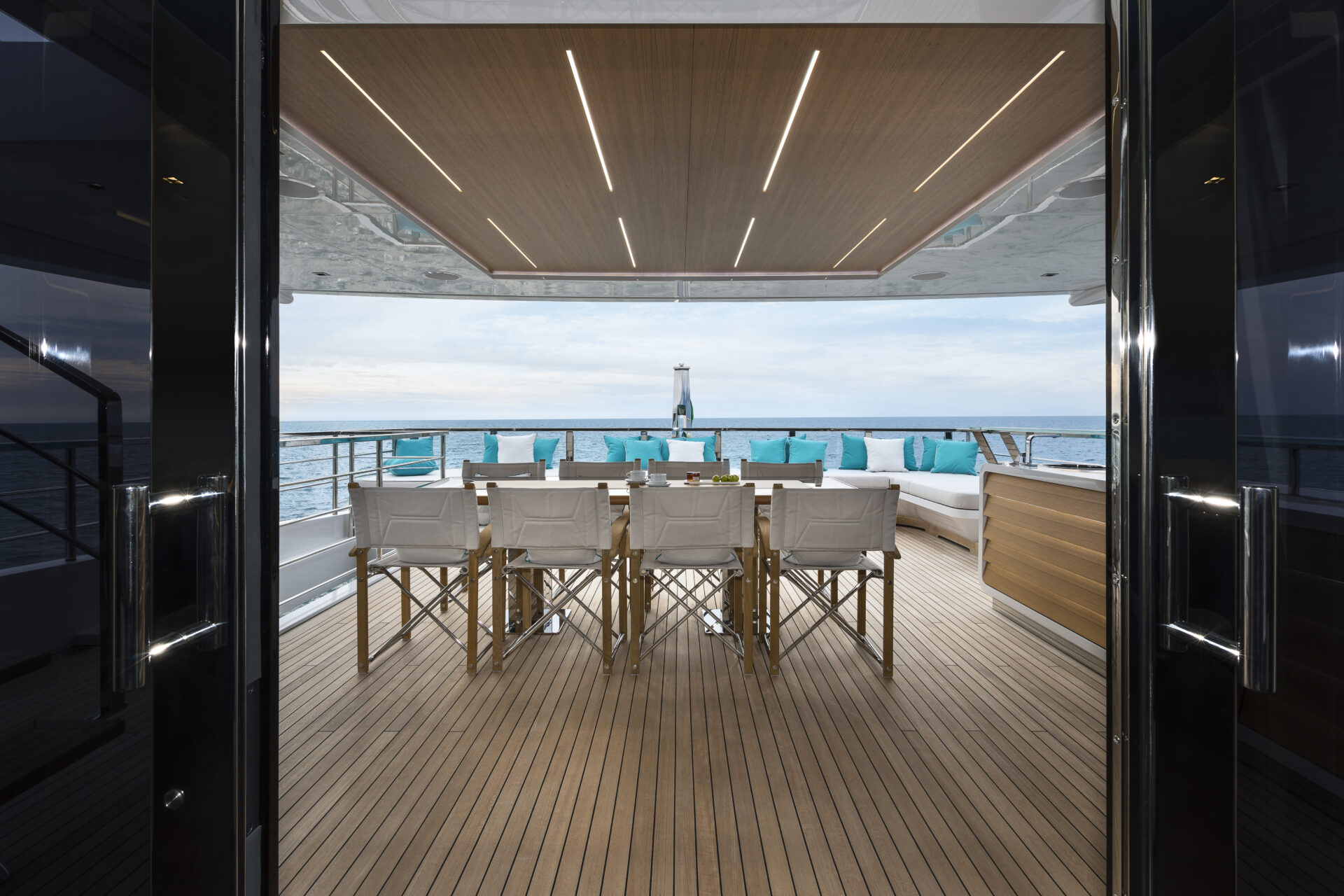 Luxury yacht deck with dining area and sea view.