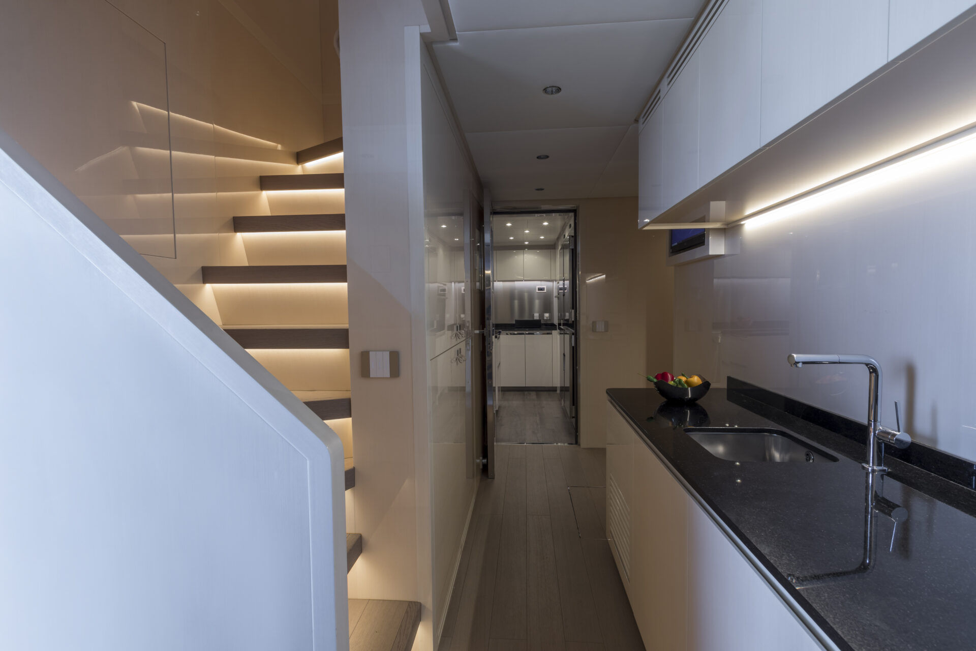 Cucina moderna e scale illuminate su yacht Mangusta.