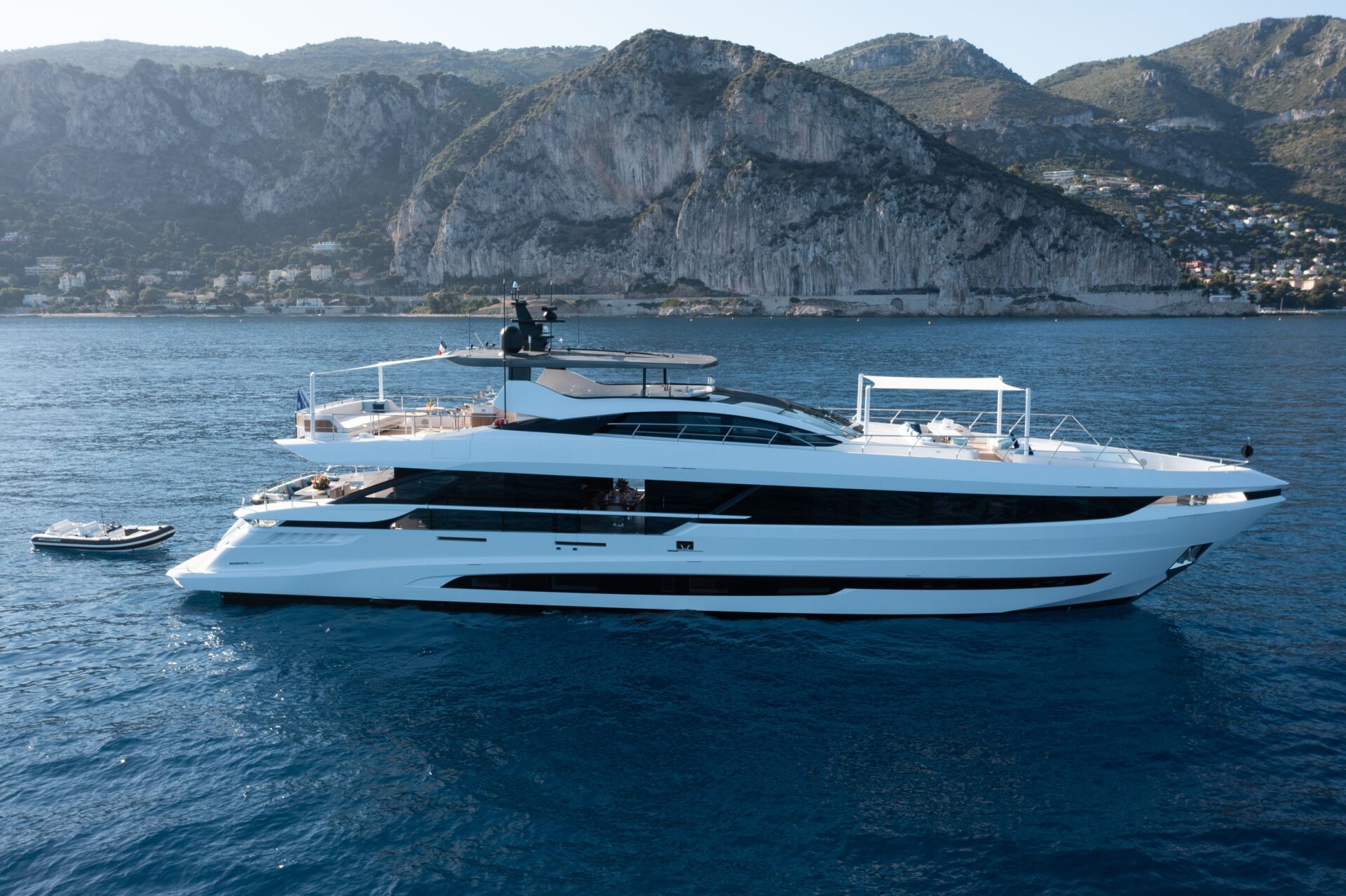 Yacht Mangusta naviga in mare con paesaggio montuoso.
