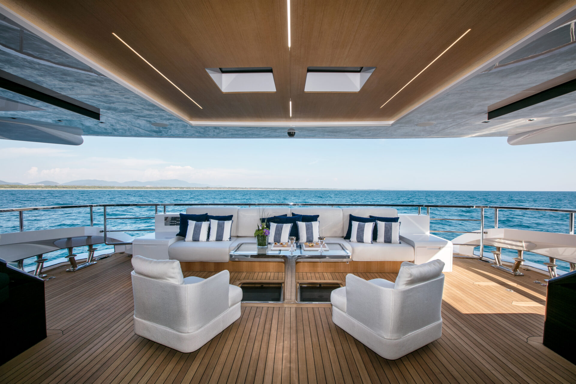 Elegant yacht deck with sea view and plush seating.