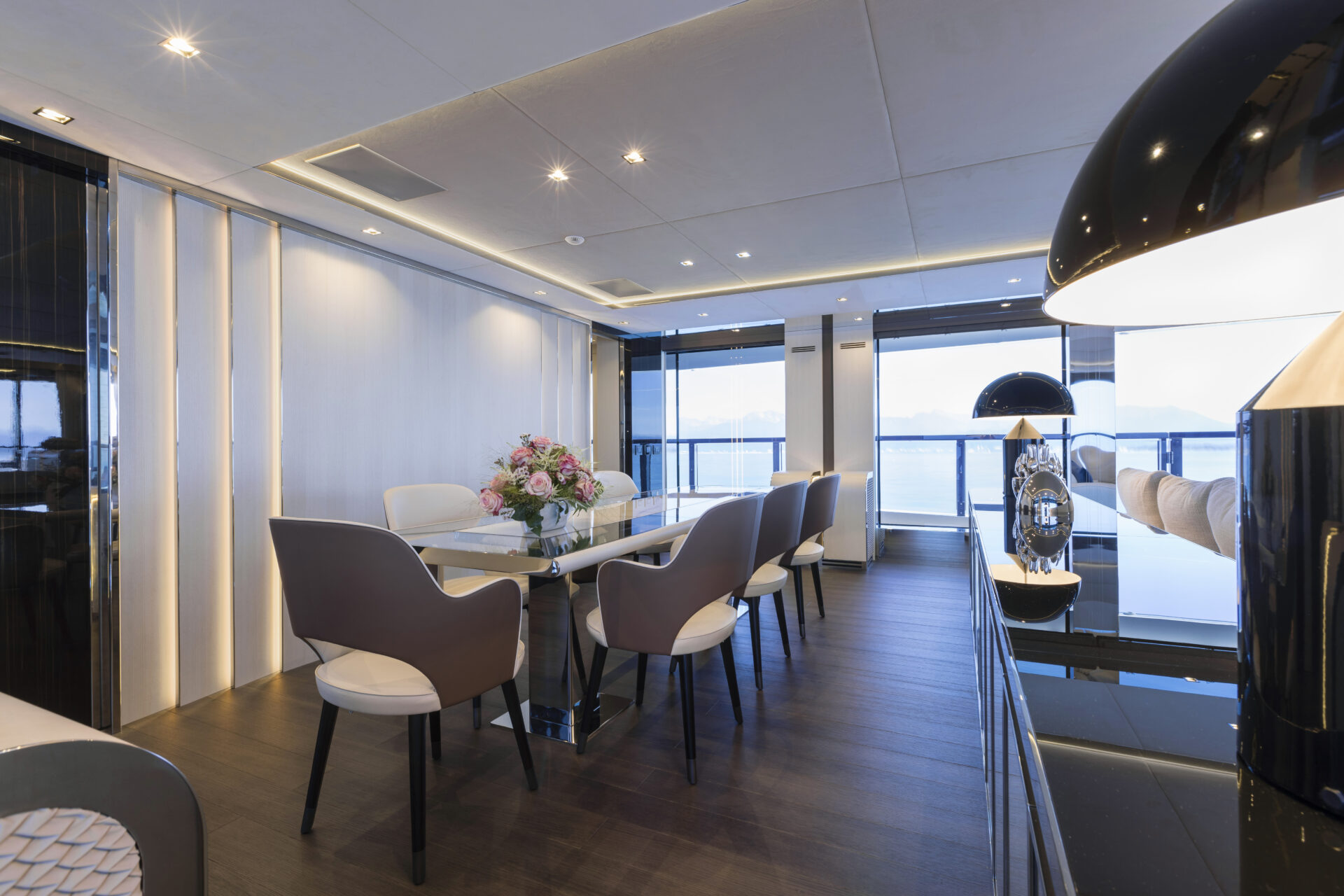 Luxury yacht interior with dining area and sea view.