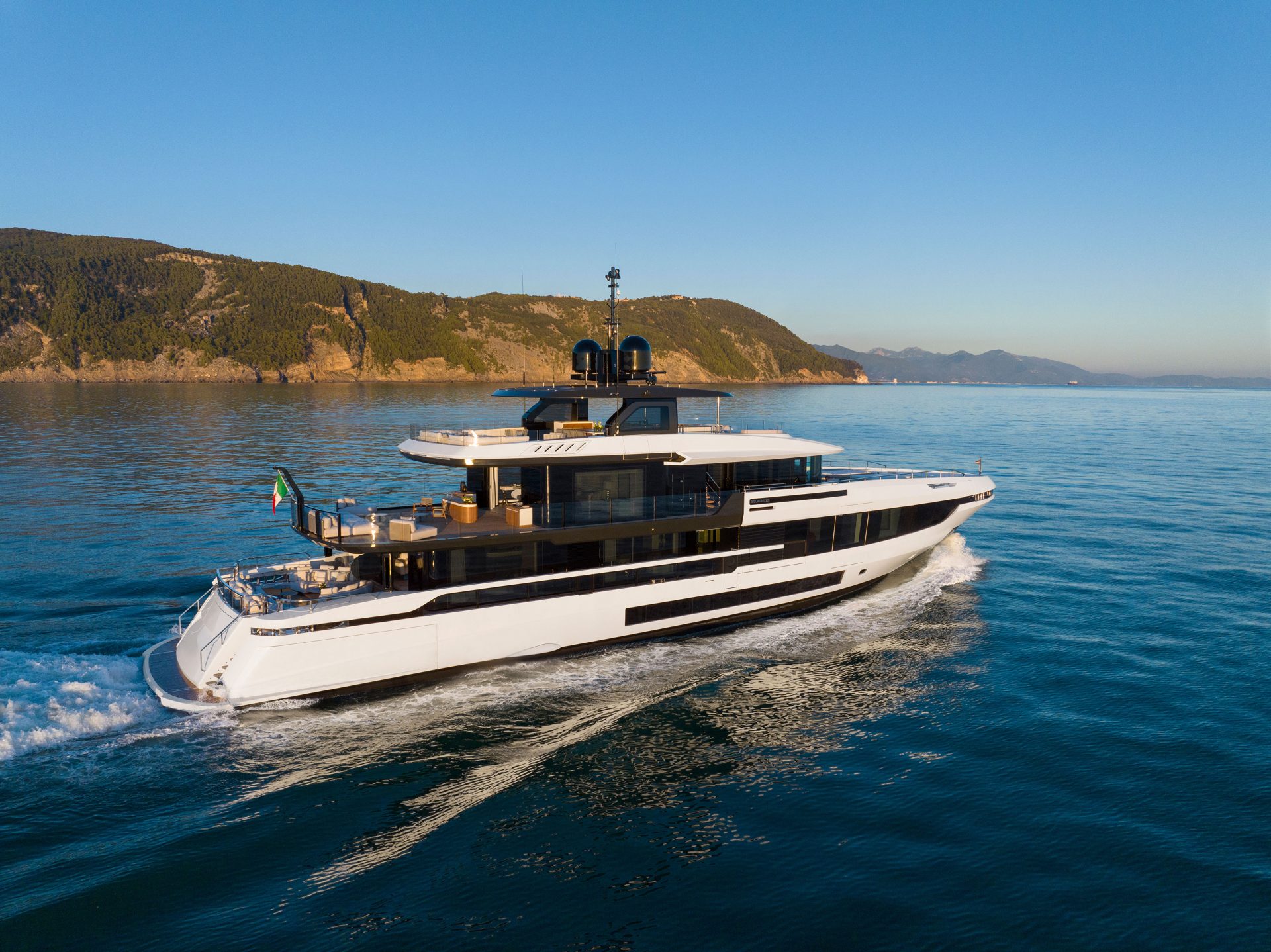 Mangusta yacht cruising off scenic coastline