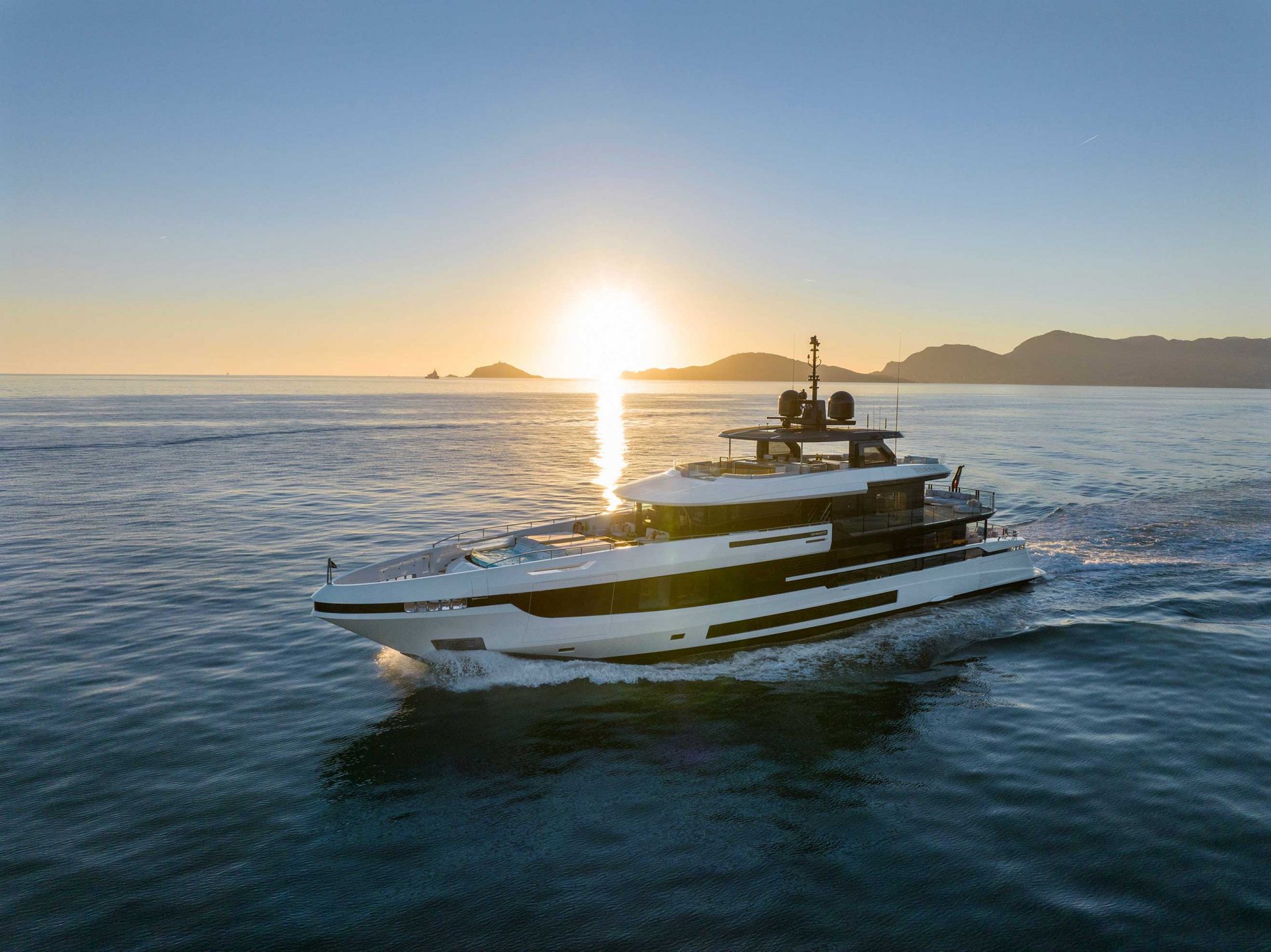 Mangusta yacht cruising at sunset, serene seascape.