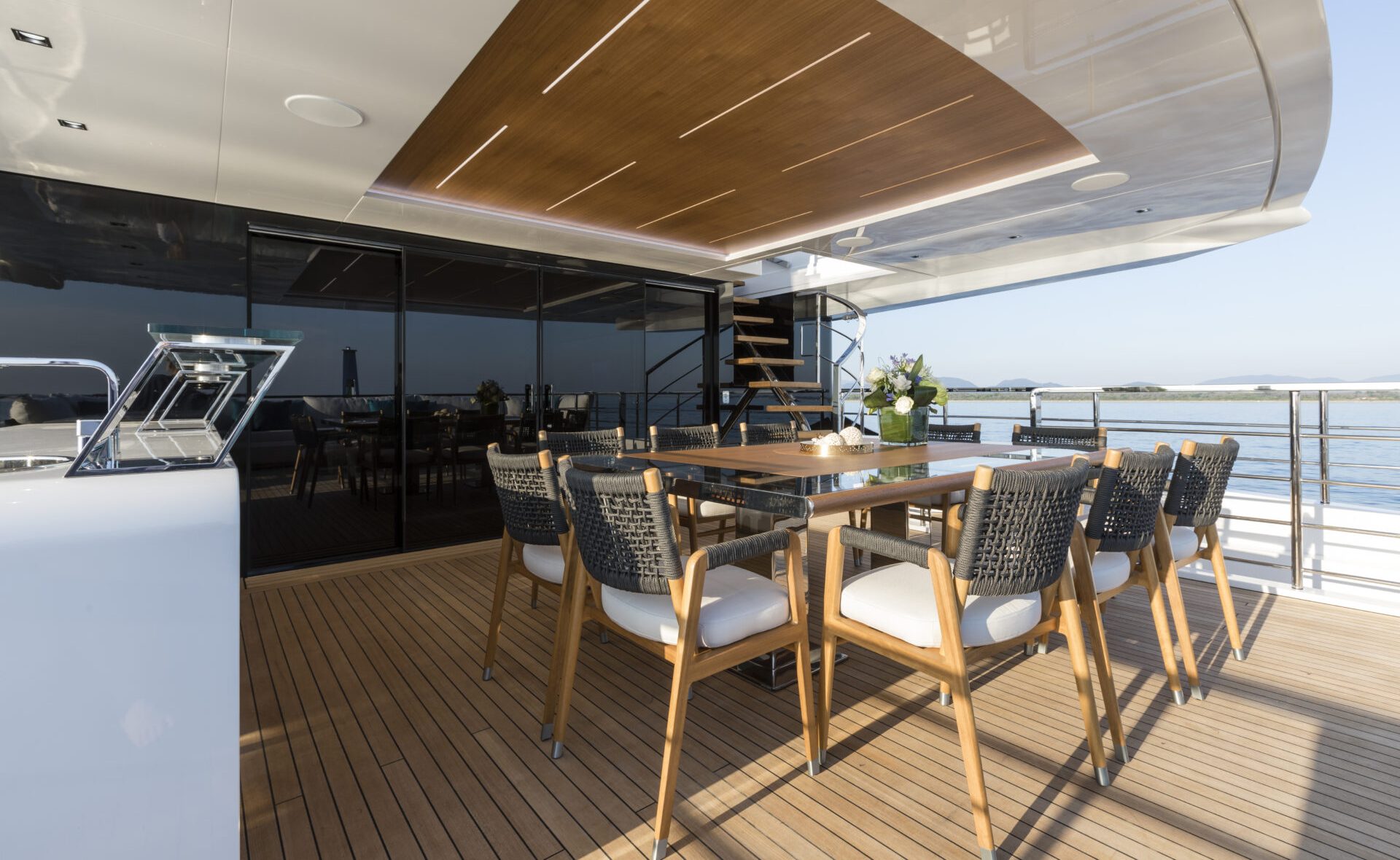 Yacht deck with elegant dining area and sea view.