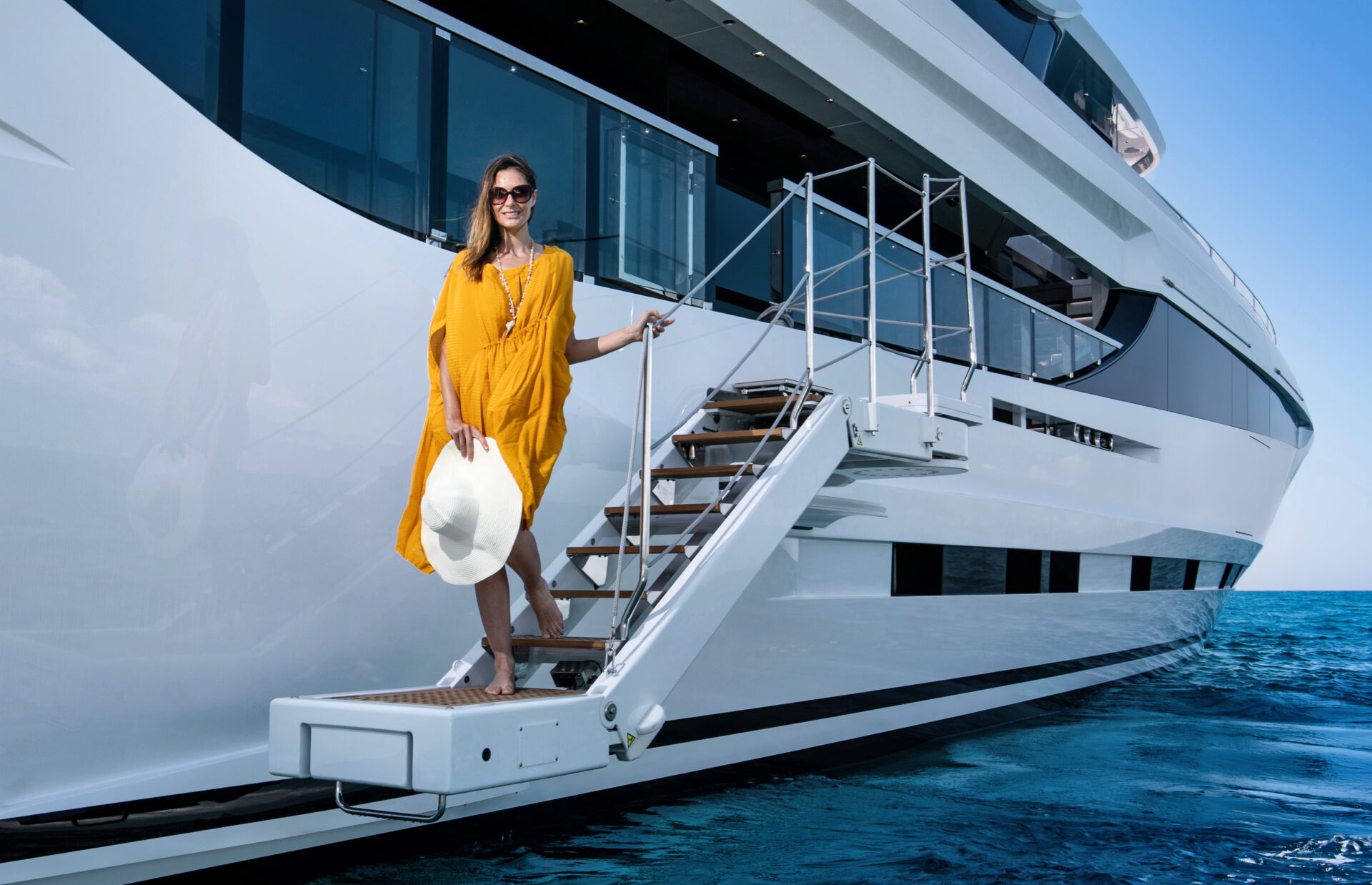 Woman on yacht stairs, Mangusta Yachts luxury.