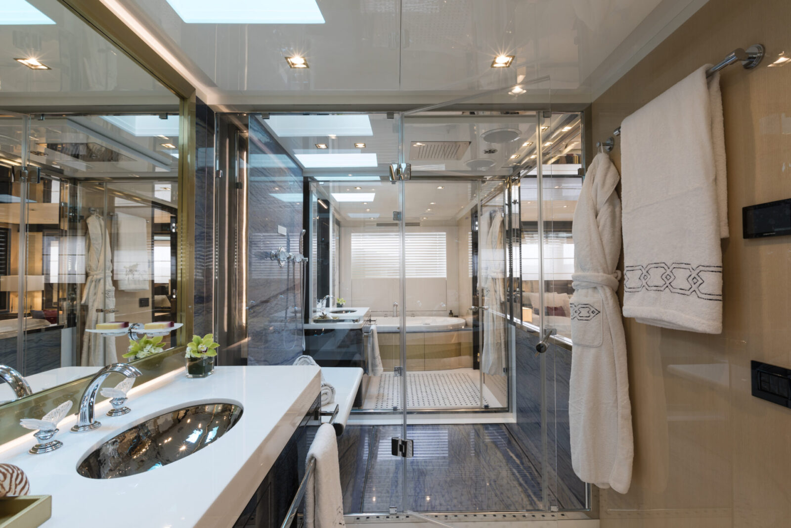 Luxurious yacht bathroom with glass shower enclosure.