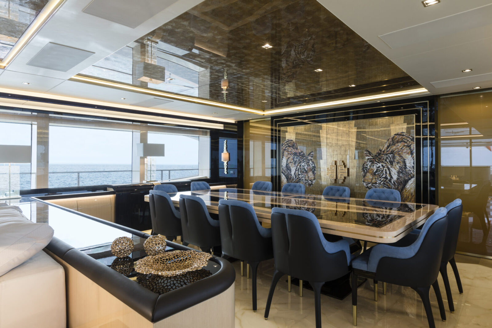 Luxury yacht dining room with sea view and tiger mural.