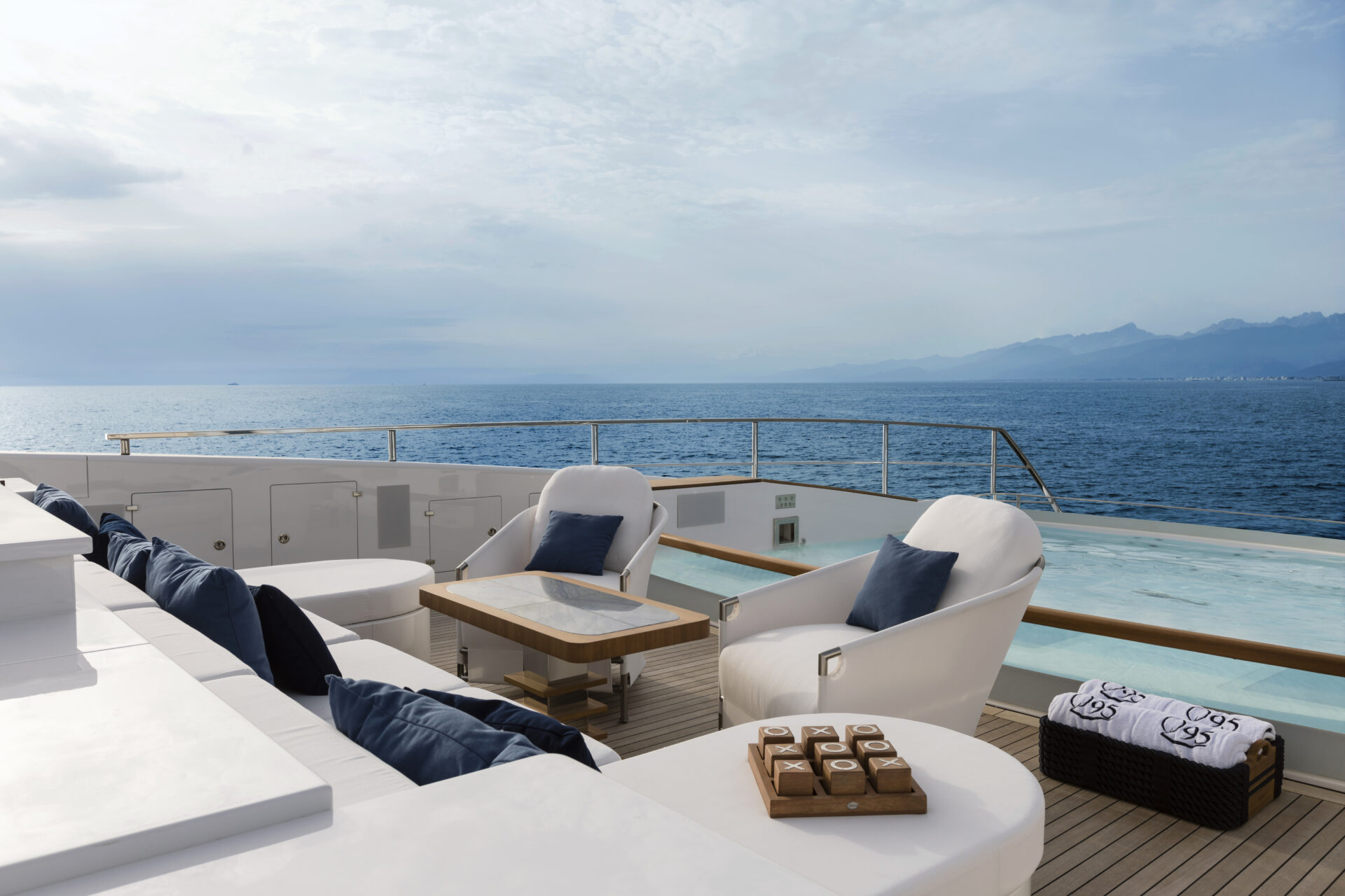 Luxury yacht deck with ocean view and seating area.