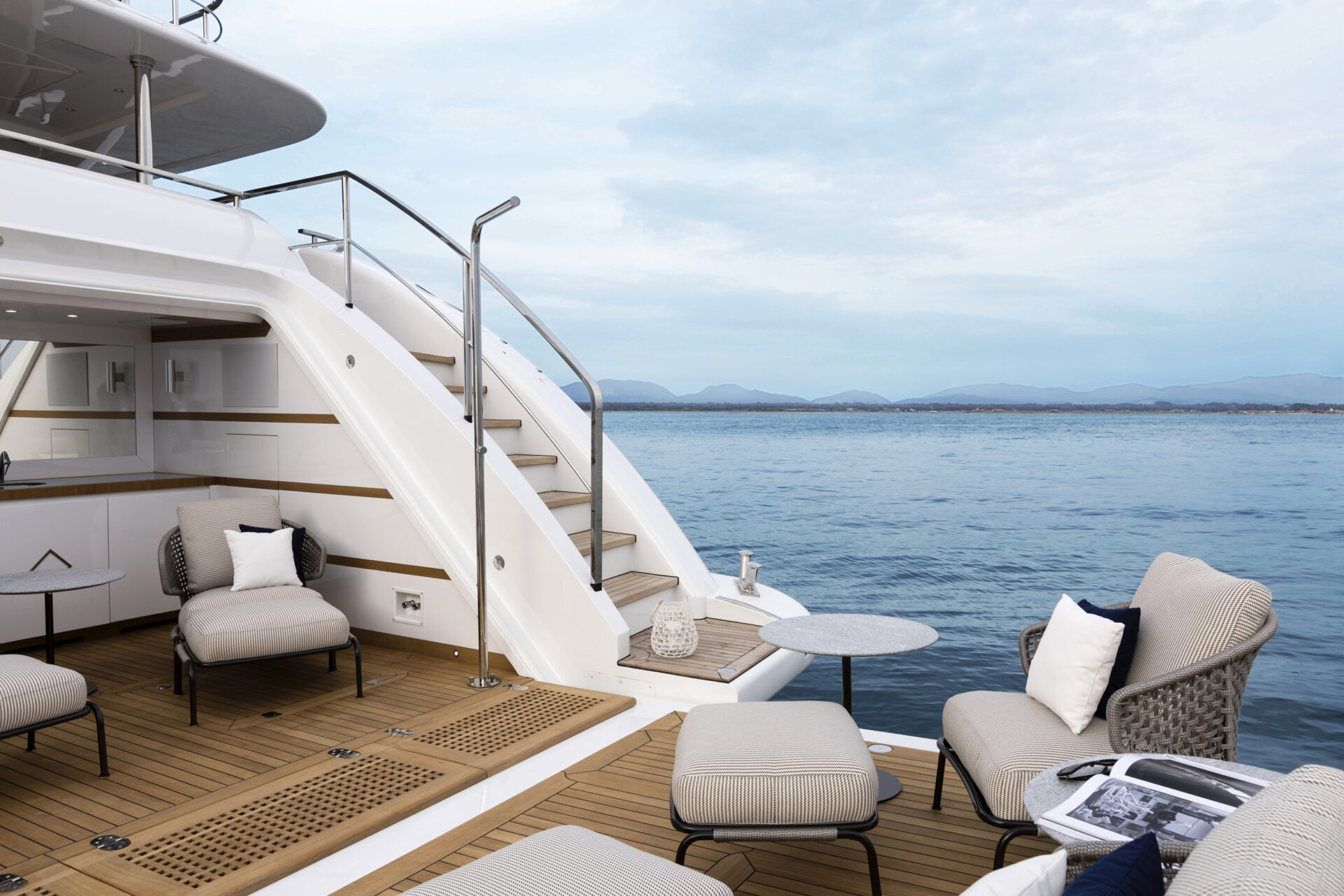 Outdoor seating on luxury yacht deck, ocean view.