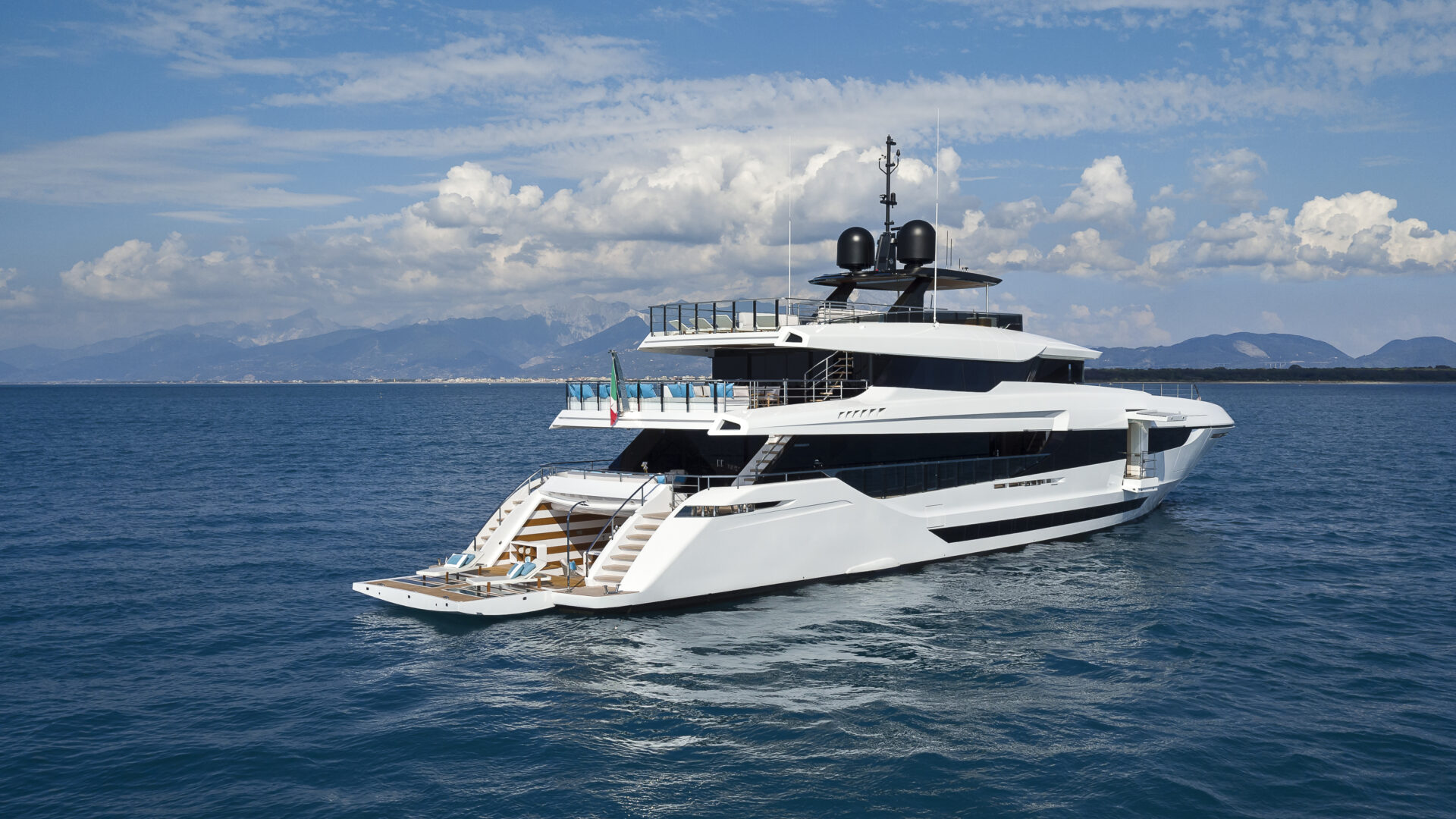 Mangusta Yacht cruising on open sea near mountains