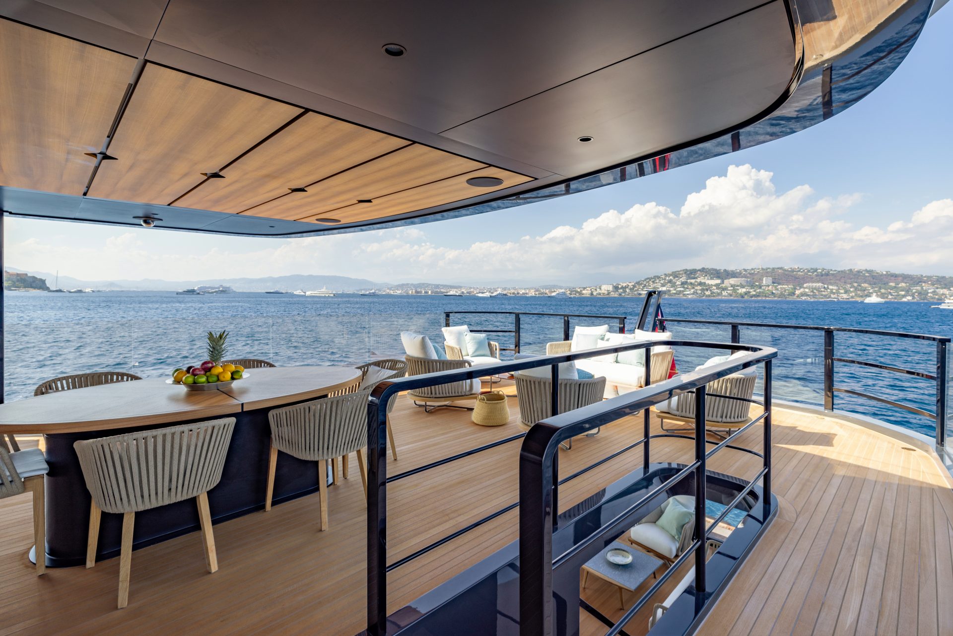 Luxury yacht deck with ocean view and dining area.