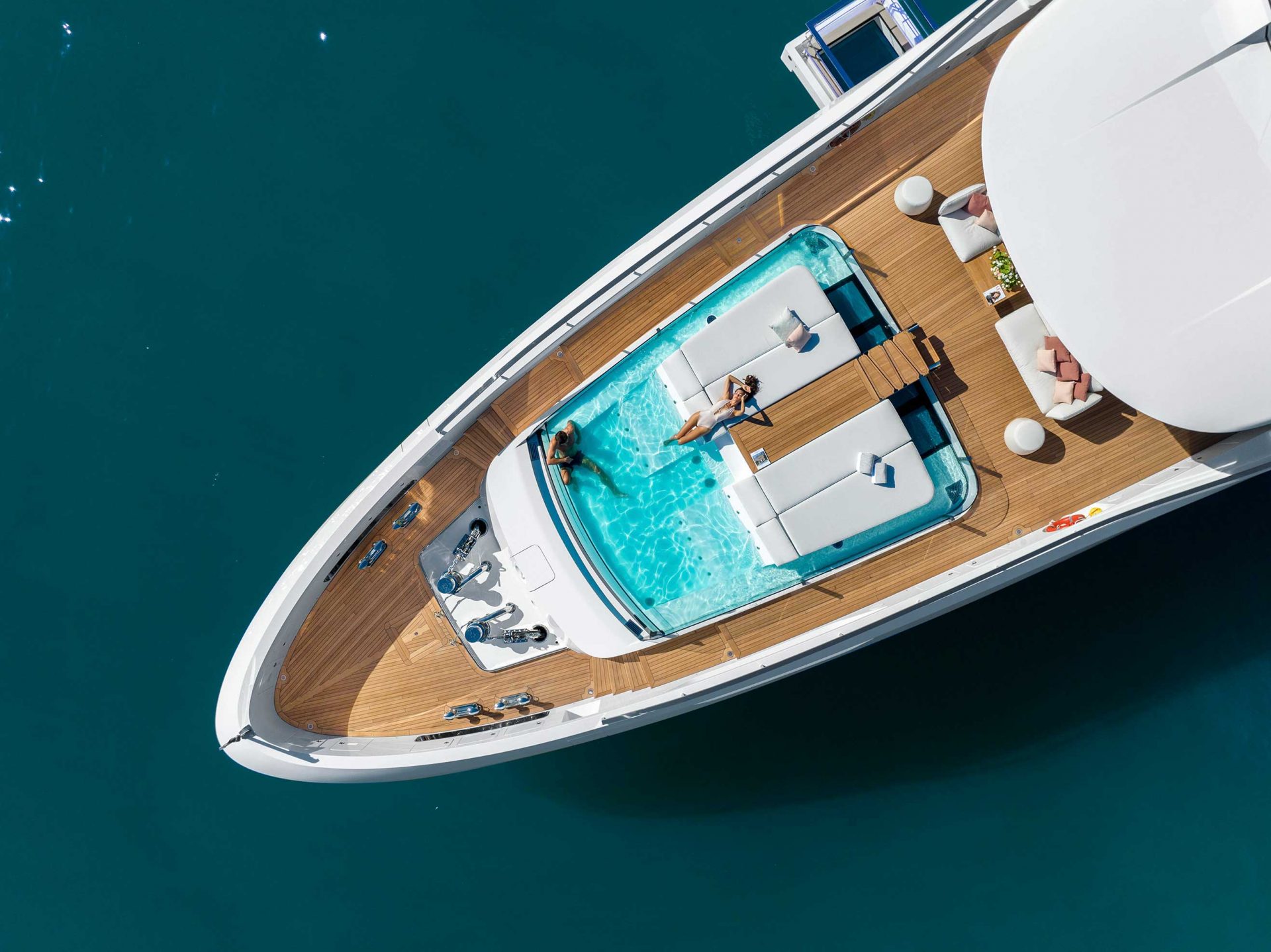 Luxurious yacht deck with pool, aerial view.