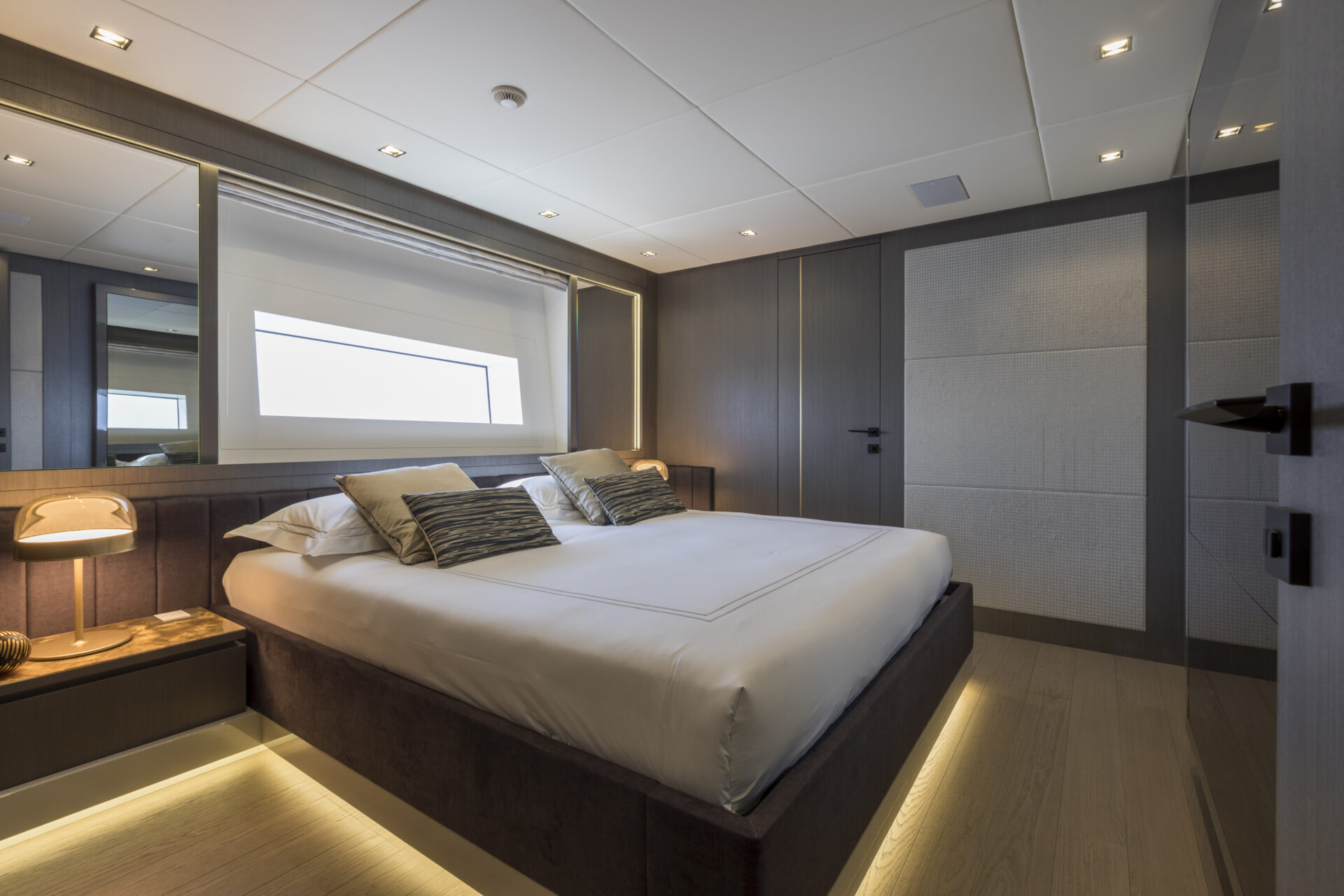 Luxurious bedroom on Mangusta yacht with window view