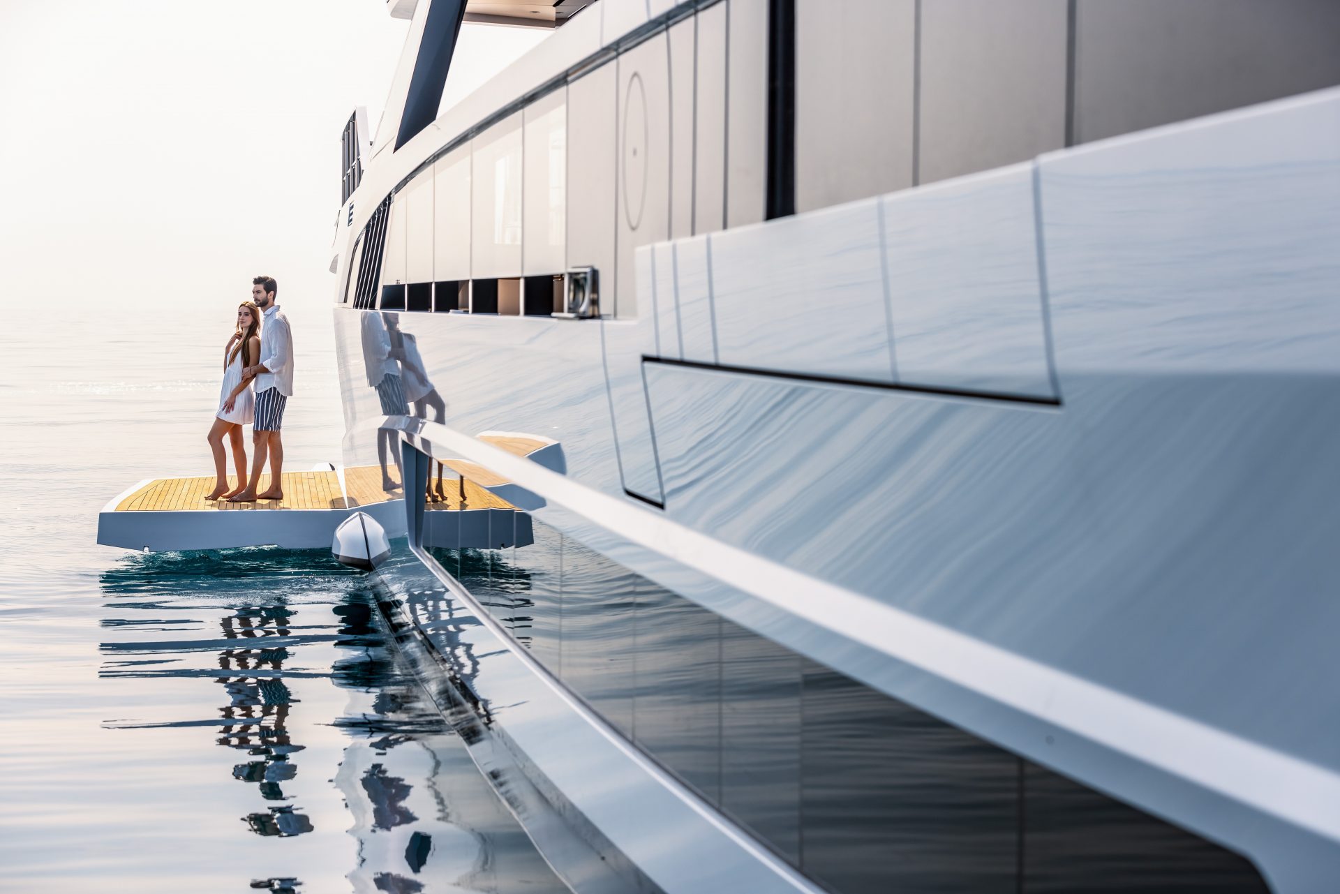 Couple on deck of luxury Mangusta Yacht at sea.