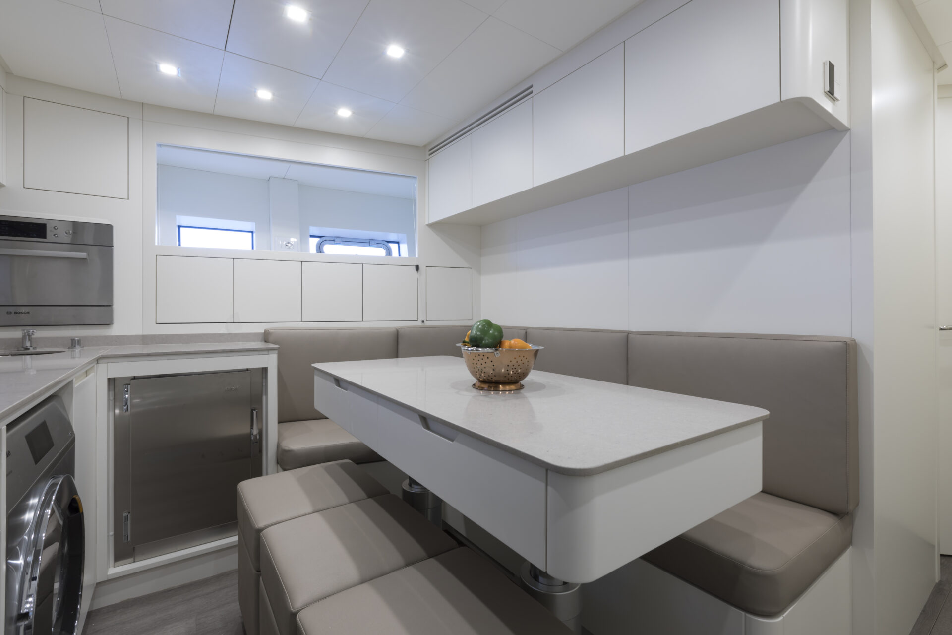 Luxury yacht kitchen with modern dining area.