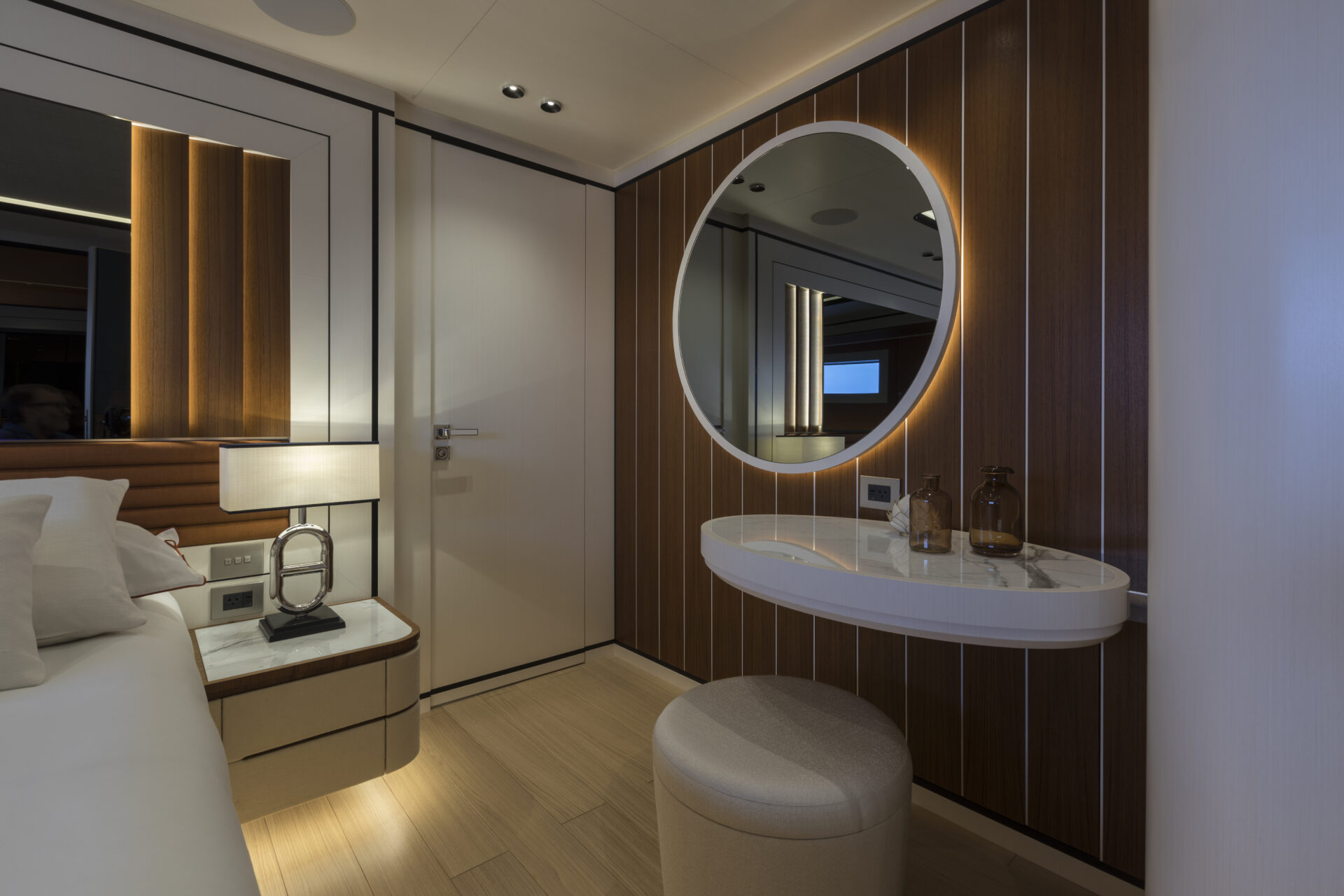Luxurious yacht cabin with wooden decor and mirror.