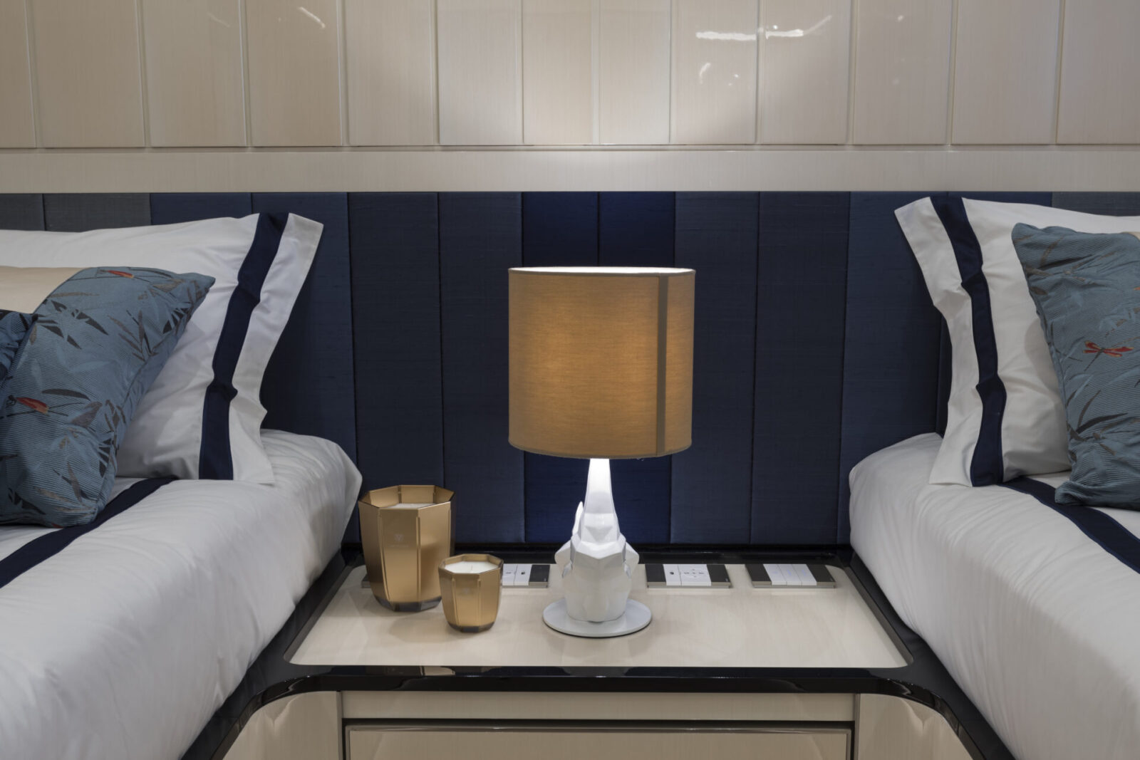 Luxury yacht cabin with elegant bed and lamp.