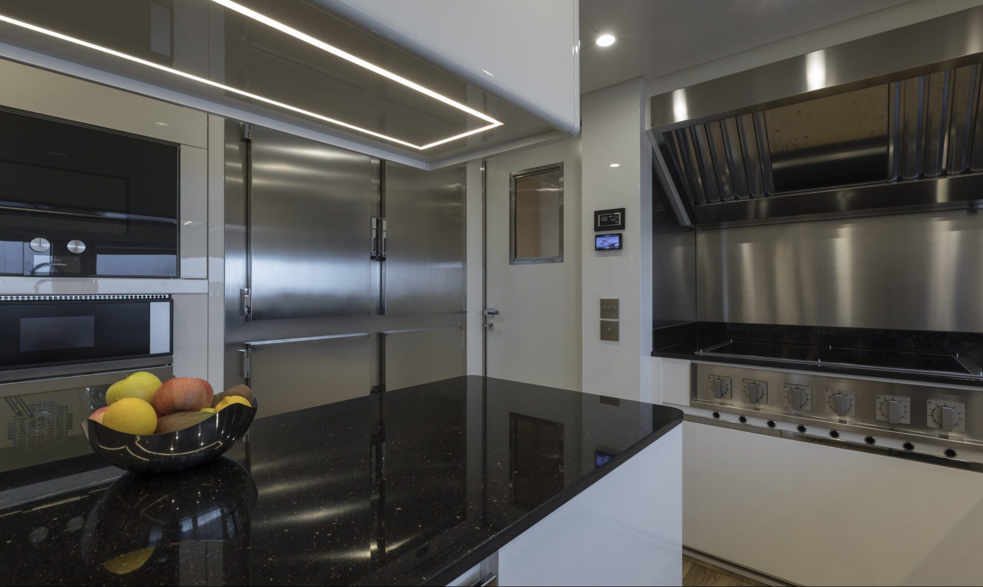 Luxury yacht kitchen interior, sleek design and fruit bowl.