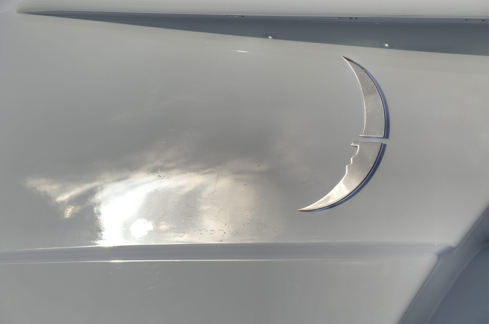 Logo Mangusta Yachts su sfondo metallico lucido.