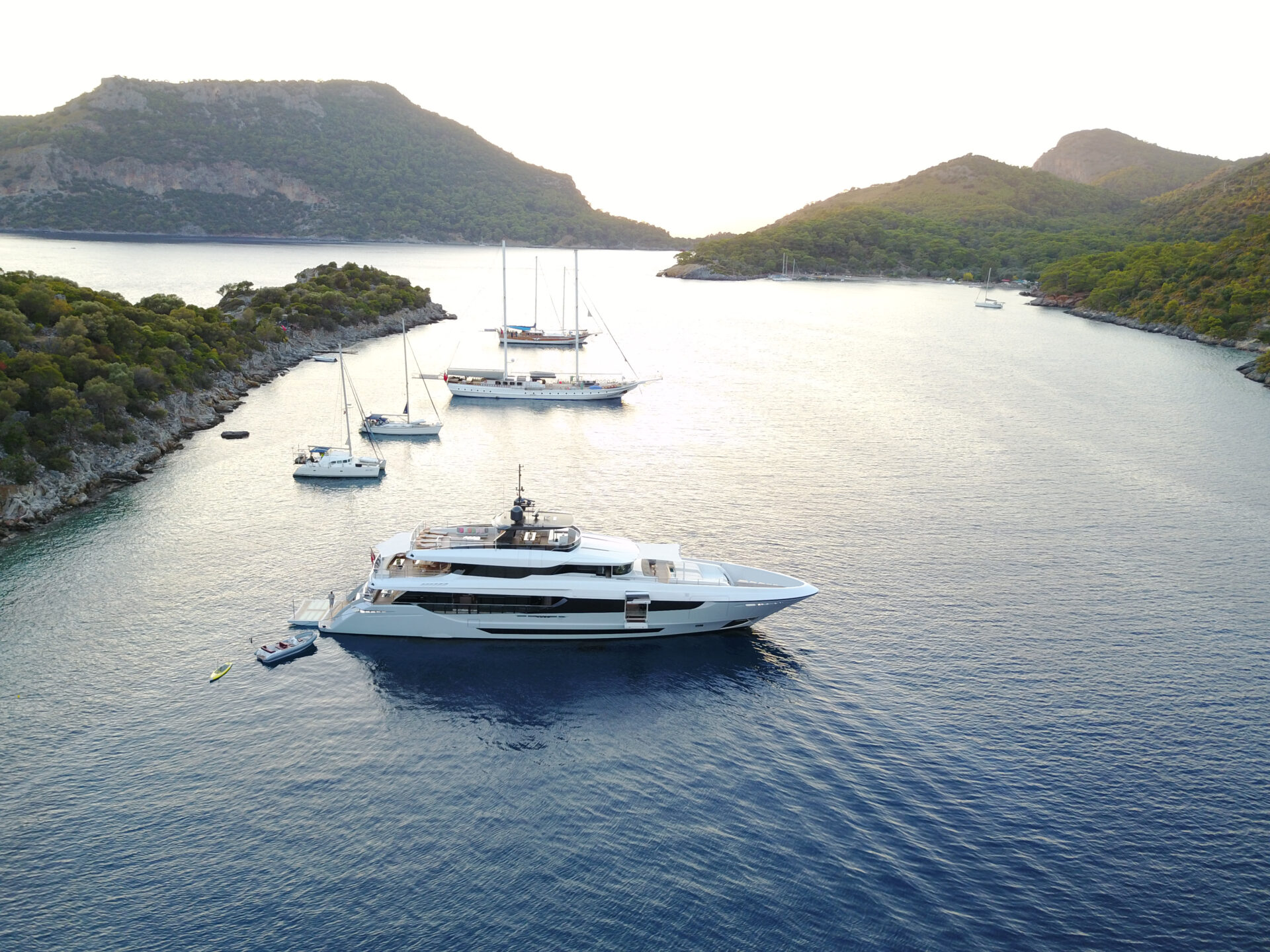 Yacht di lusso Mangusta in baia tranquilla al tramonto.