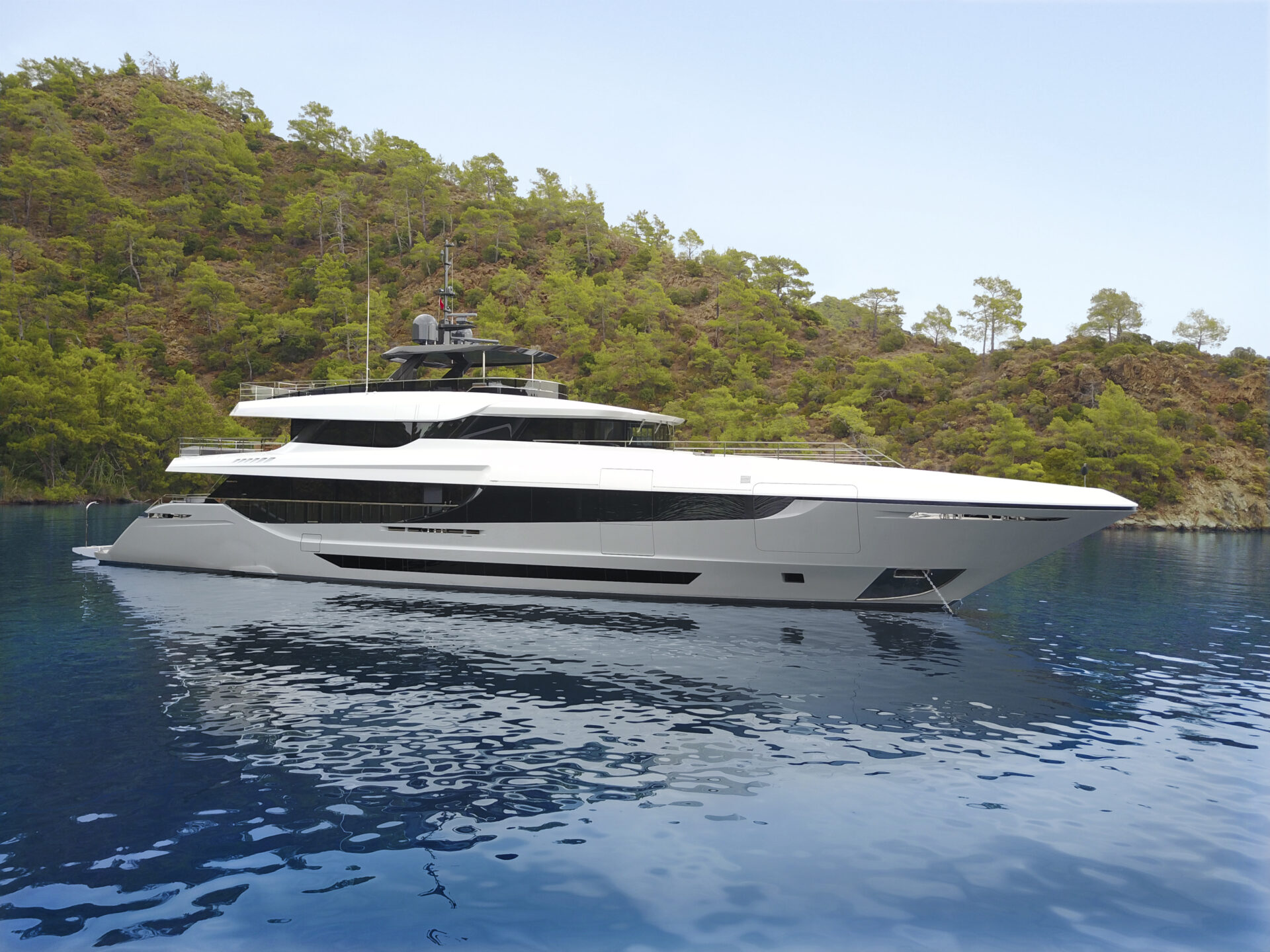 Yacht di lusso Mangusta in baia verde rigogliosa.