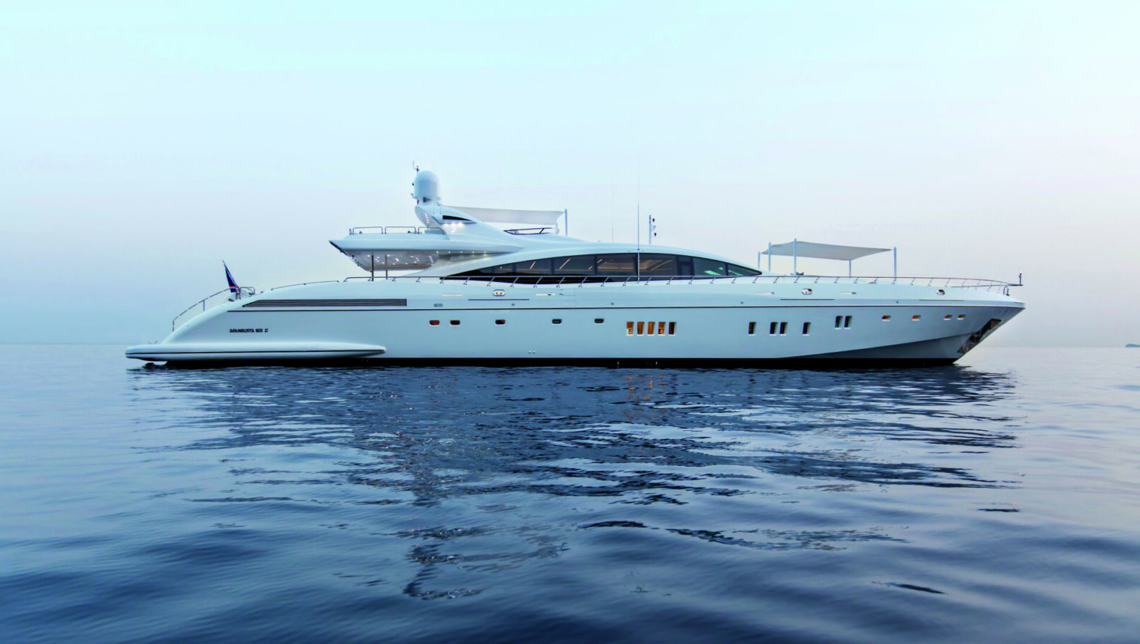 Yacht Mangusta 165 all'alba sul mare tranquillo.