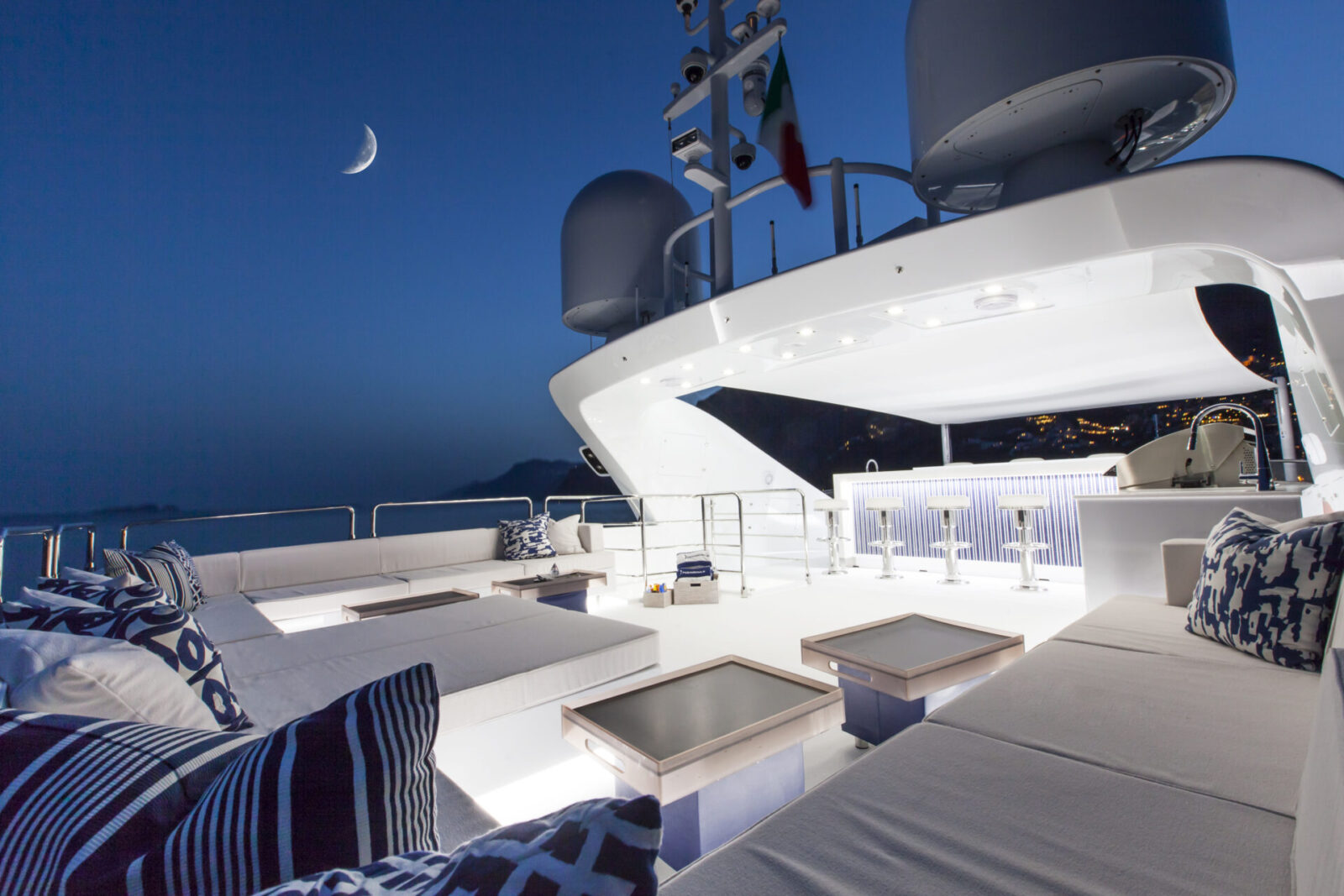 Ponte relax Mangusta Yachts al tramonto, luna brillante.