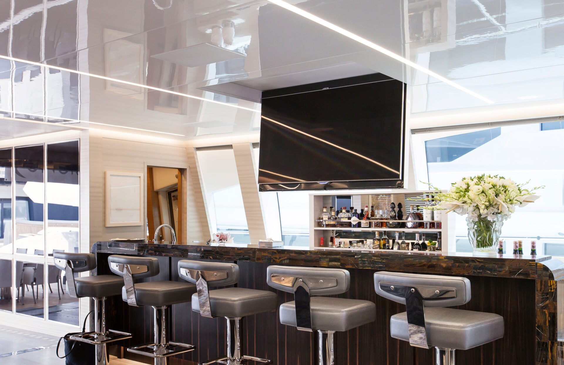 Bar moderno su yacht Mangusta con sgabelli eleganti.