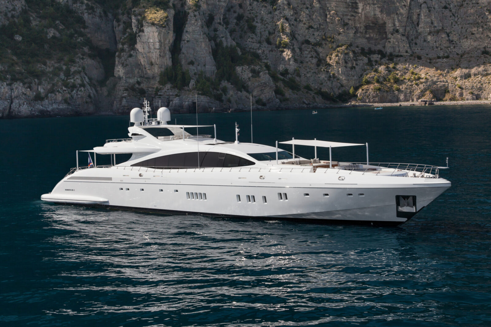 Yacht Mangusta ancorato in baia rocciosa.