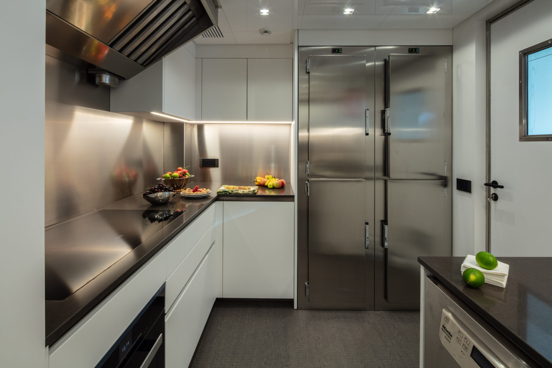 Modern yacht kitchen with stainless steel appliances.