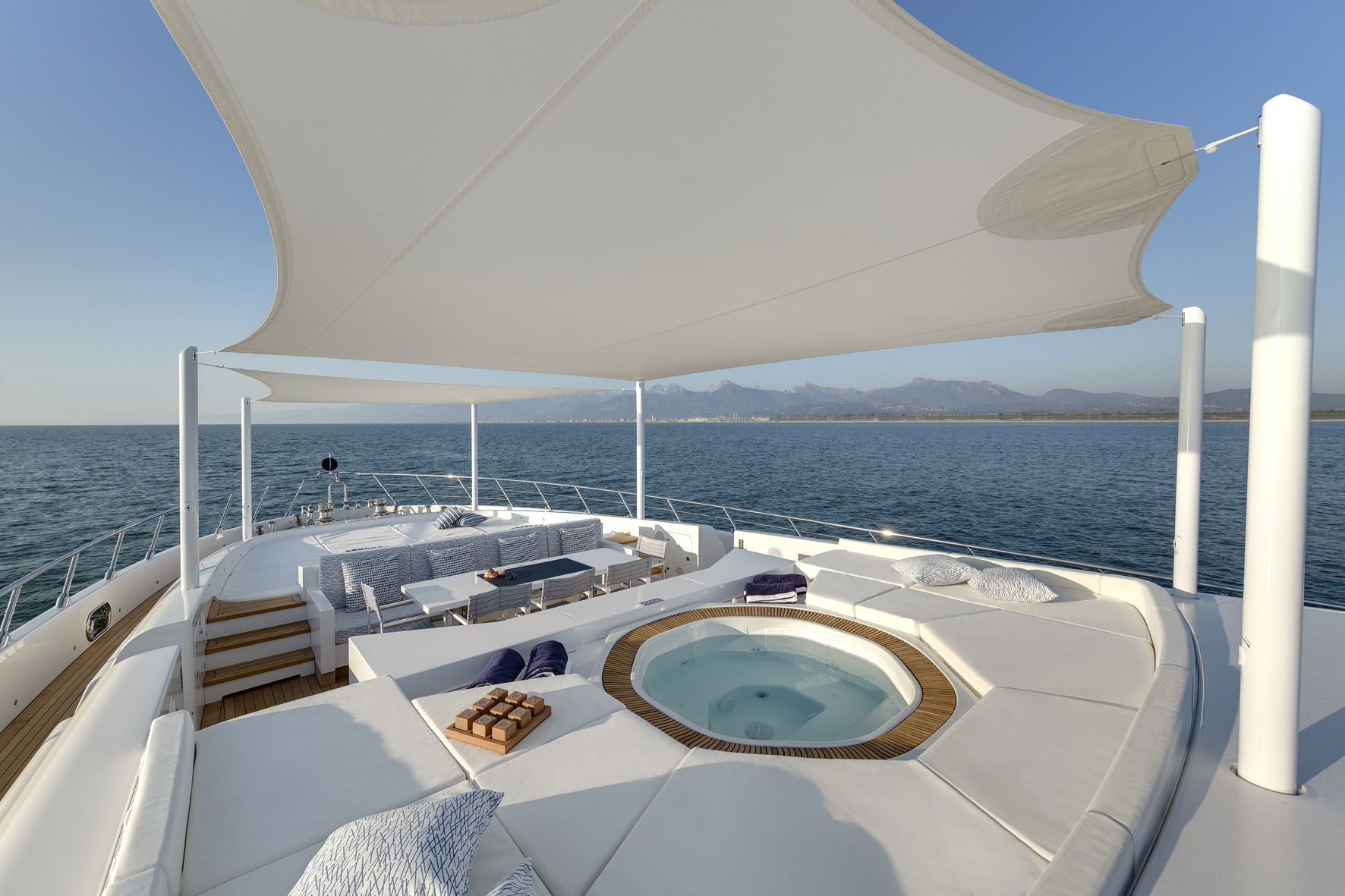 Luxury yacht deck with jacuzzi and ocean view.