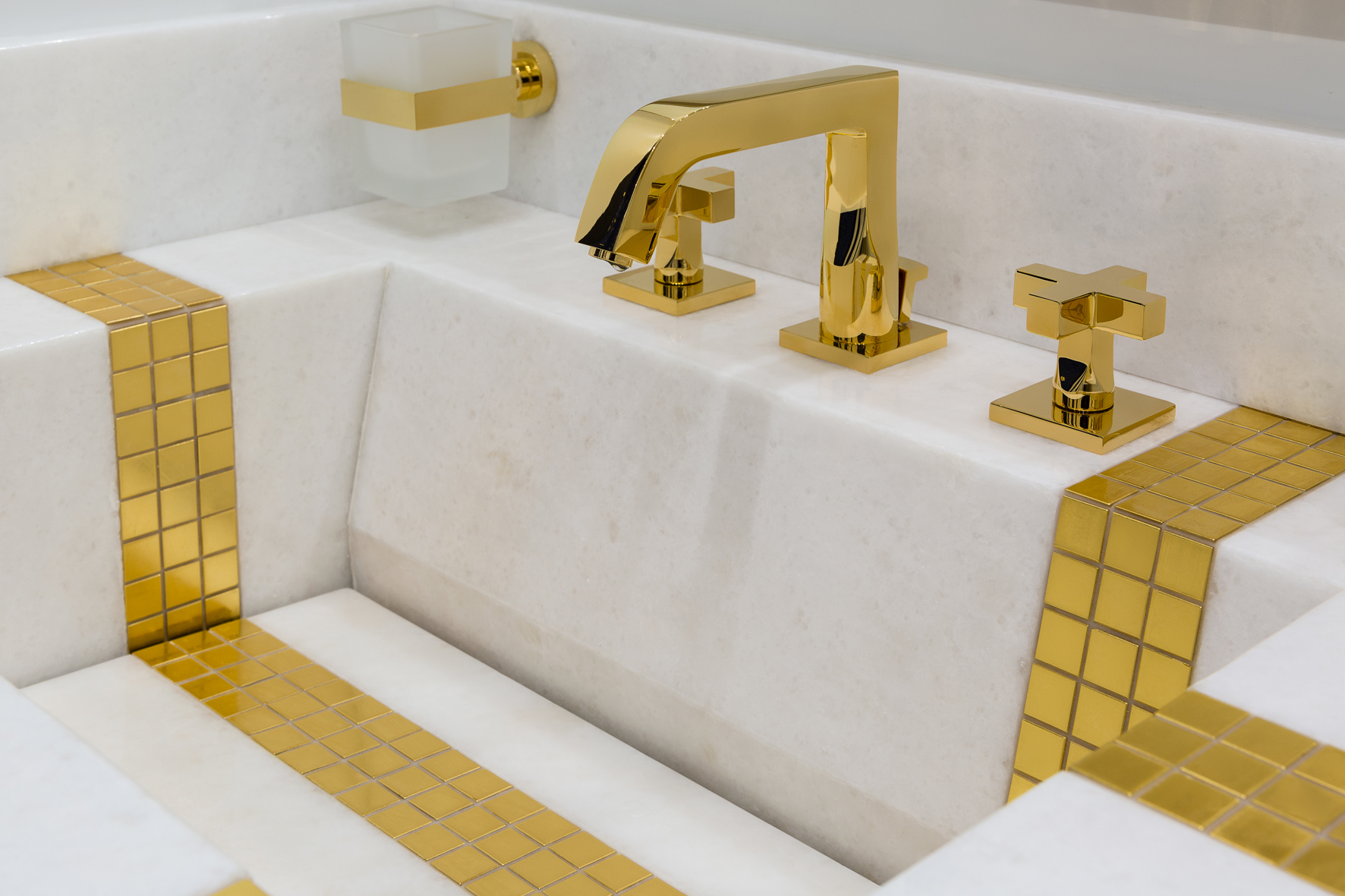 Golden faucet with marble basin on luxury yacht