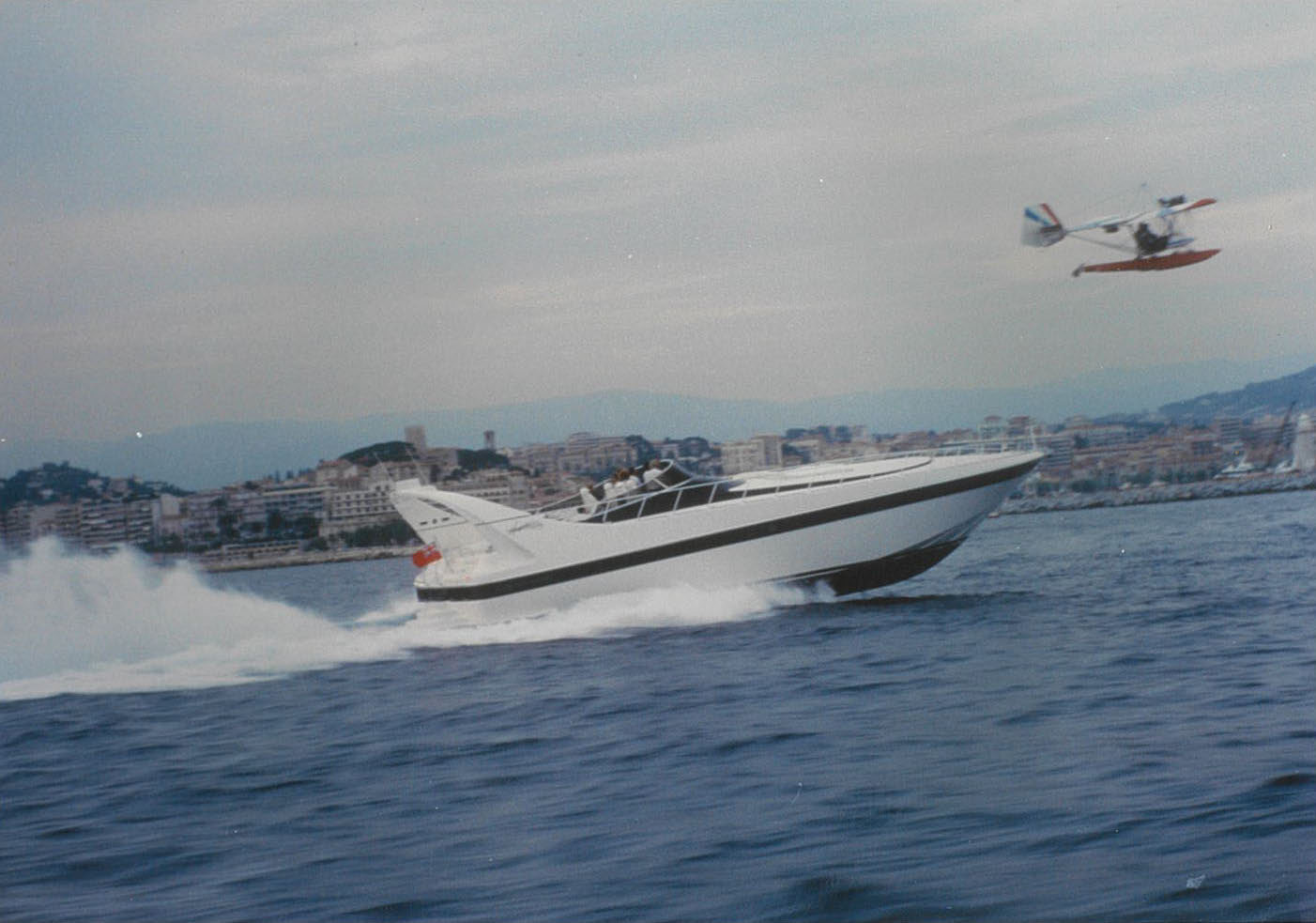 Mangusta yacht speeding near coastline.