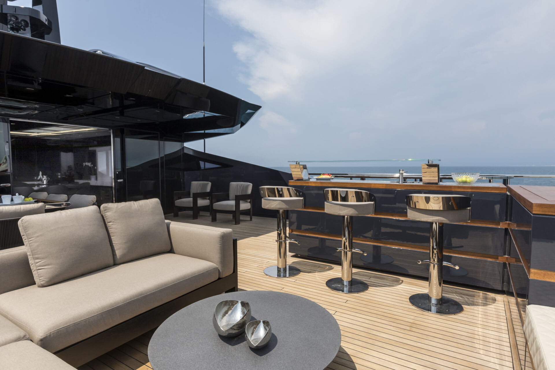 Soggiorno esterno su yacht Mangusta con vista mare.