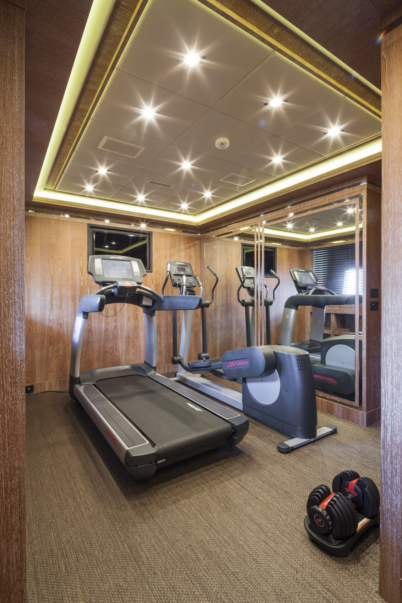 Luxury yacht gym with treadmill and dumbbells