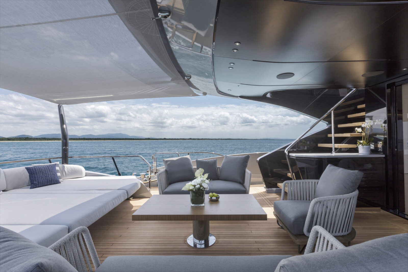 Luxury yacht deck with seating area and sea view.