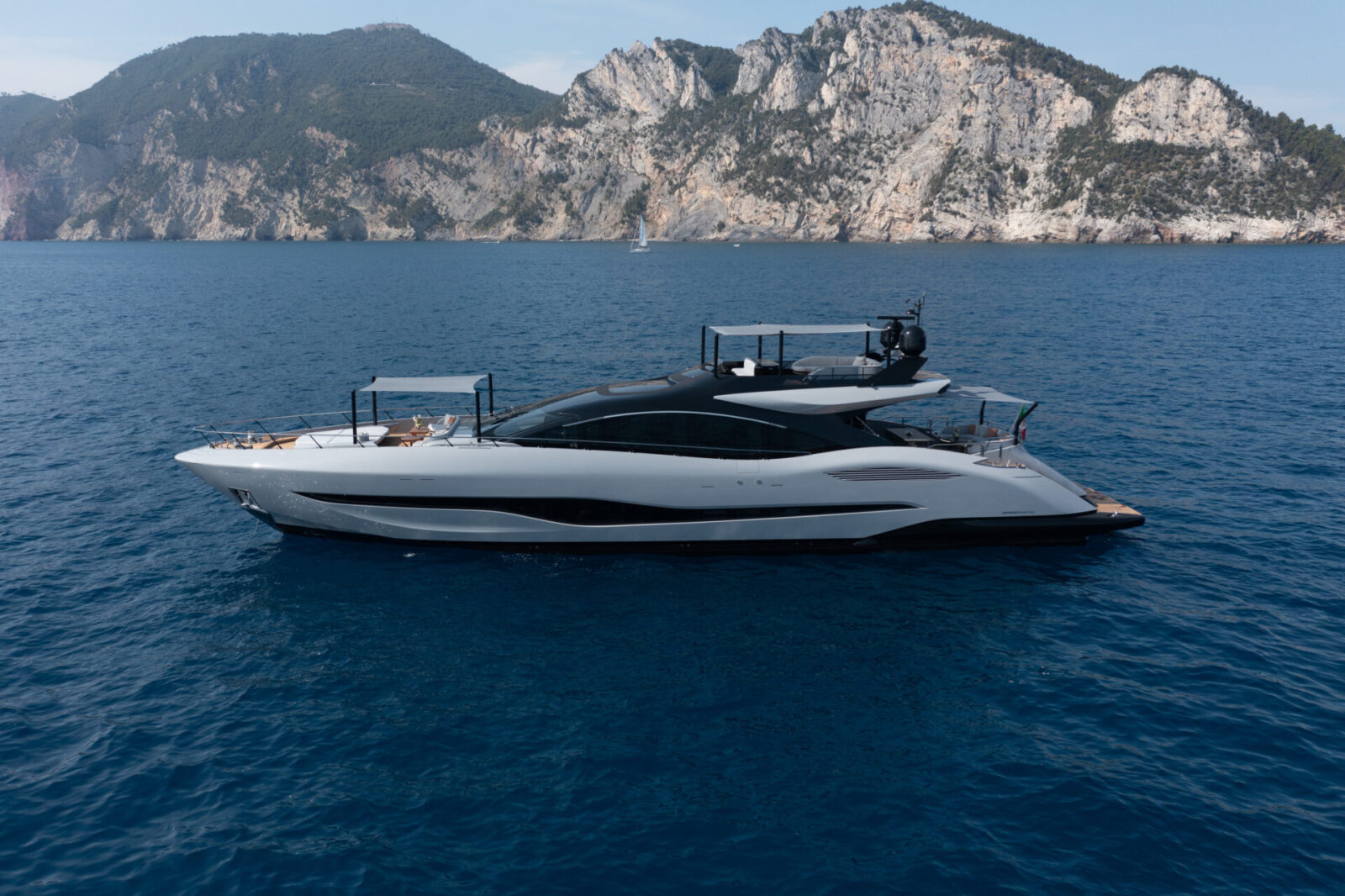 Yacht Mangusta al largo della costa rocciosa.