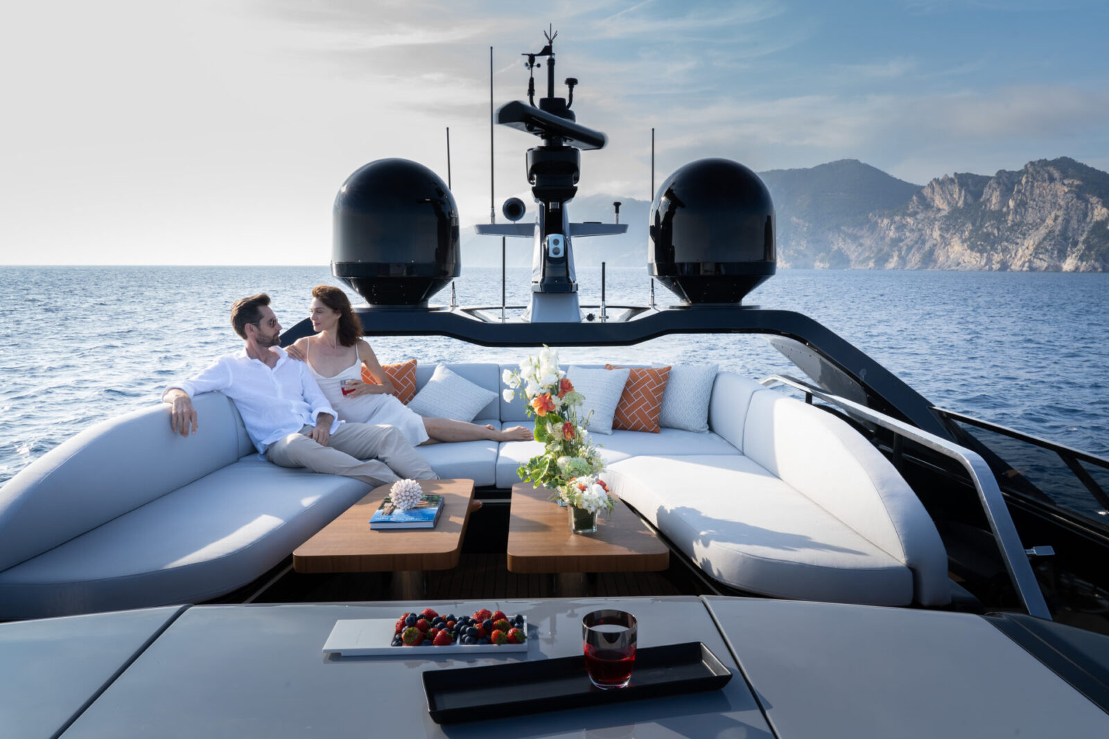 Coppia rilassata su yacht Mangusta in mare aperto.