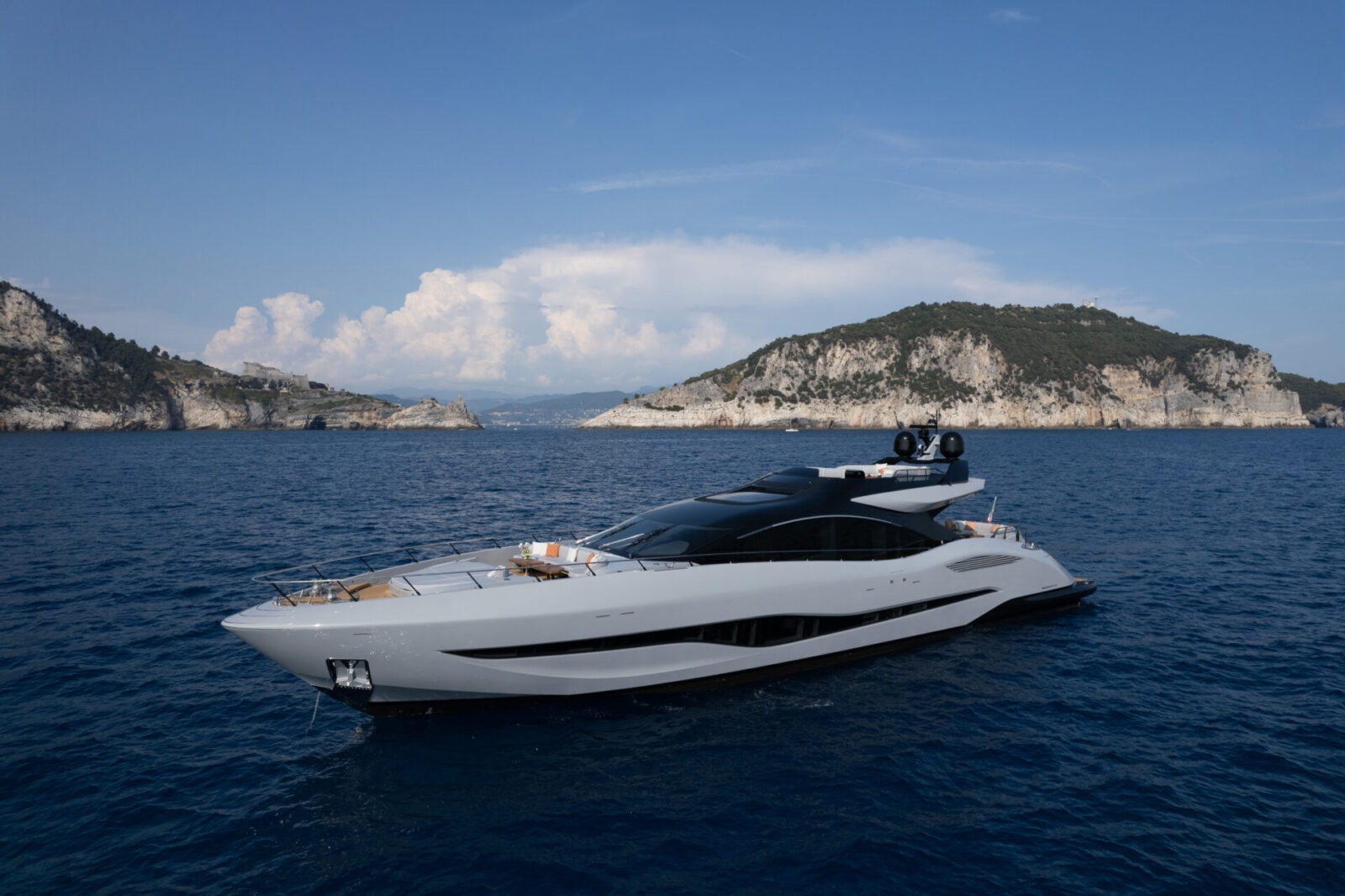 Yacht Mangusta al largo della costa rocciosa.