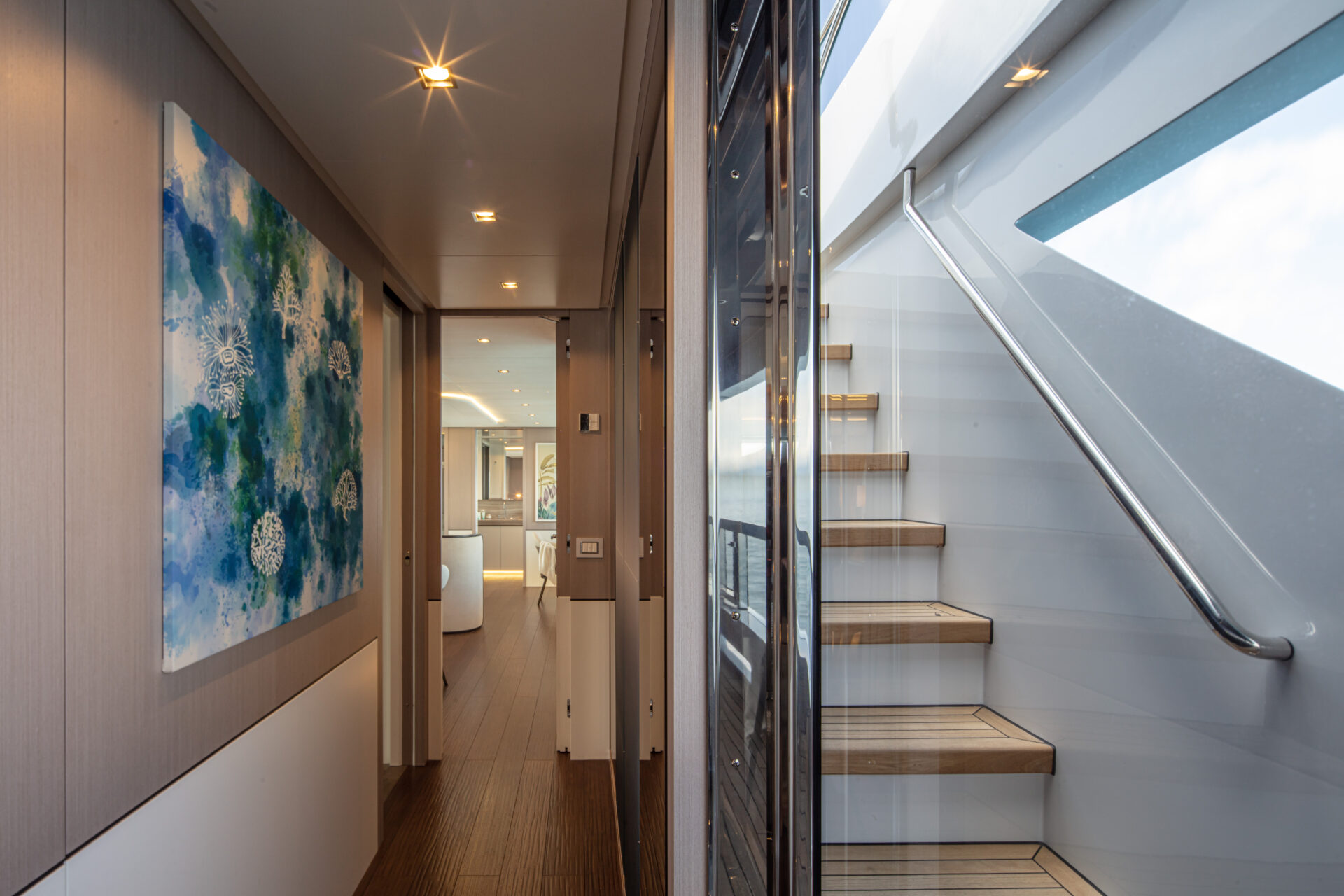 Corridoio elegante con scala e quadro moderno.