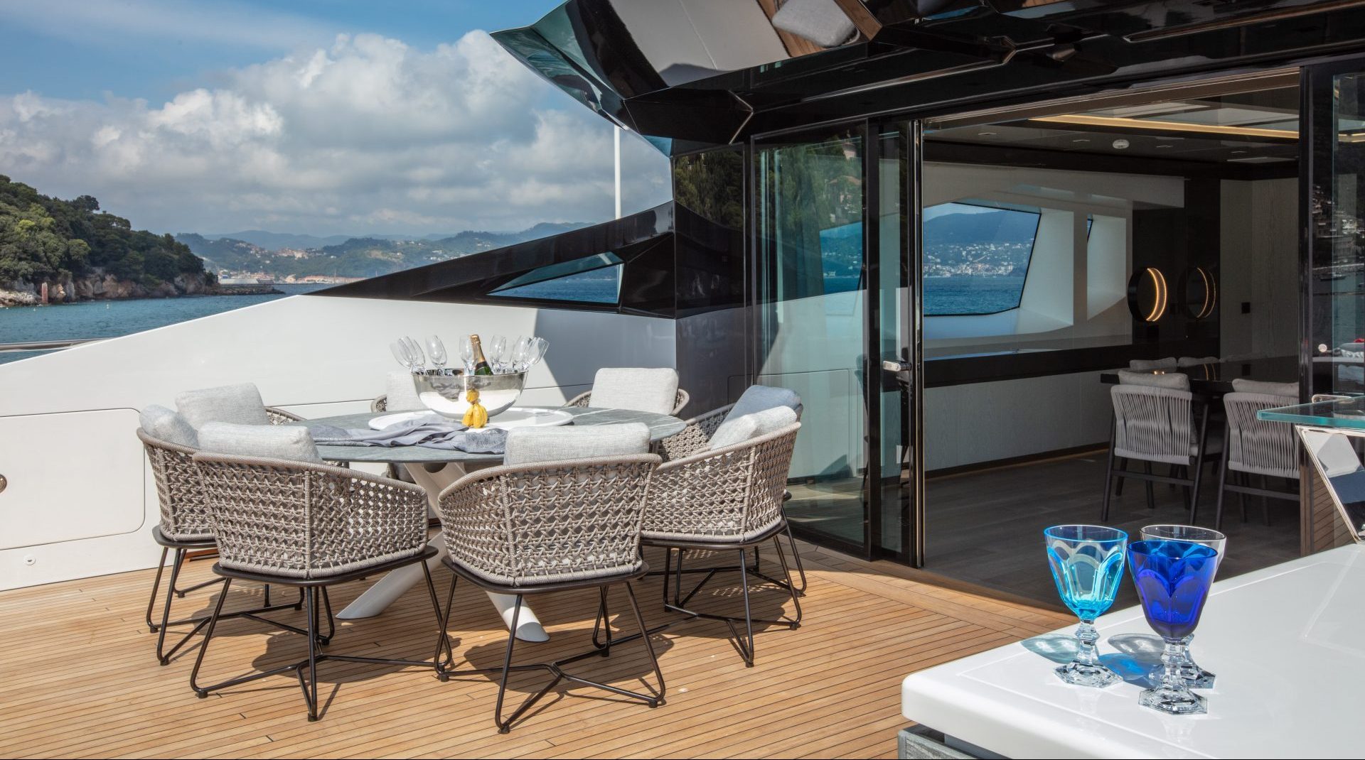 Elegant yacht deck with dining area at sea.